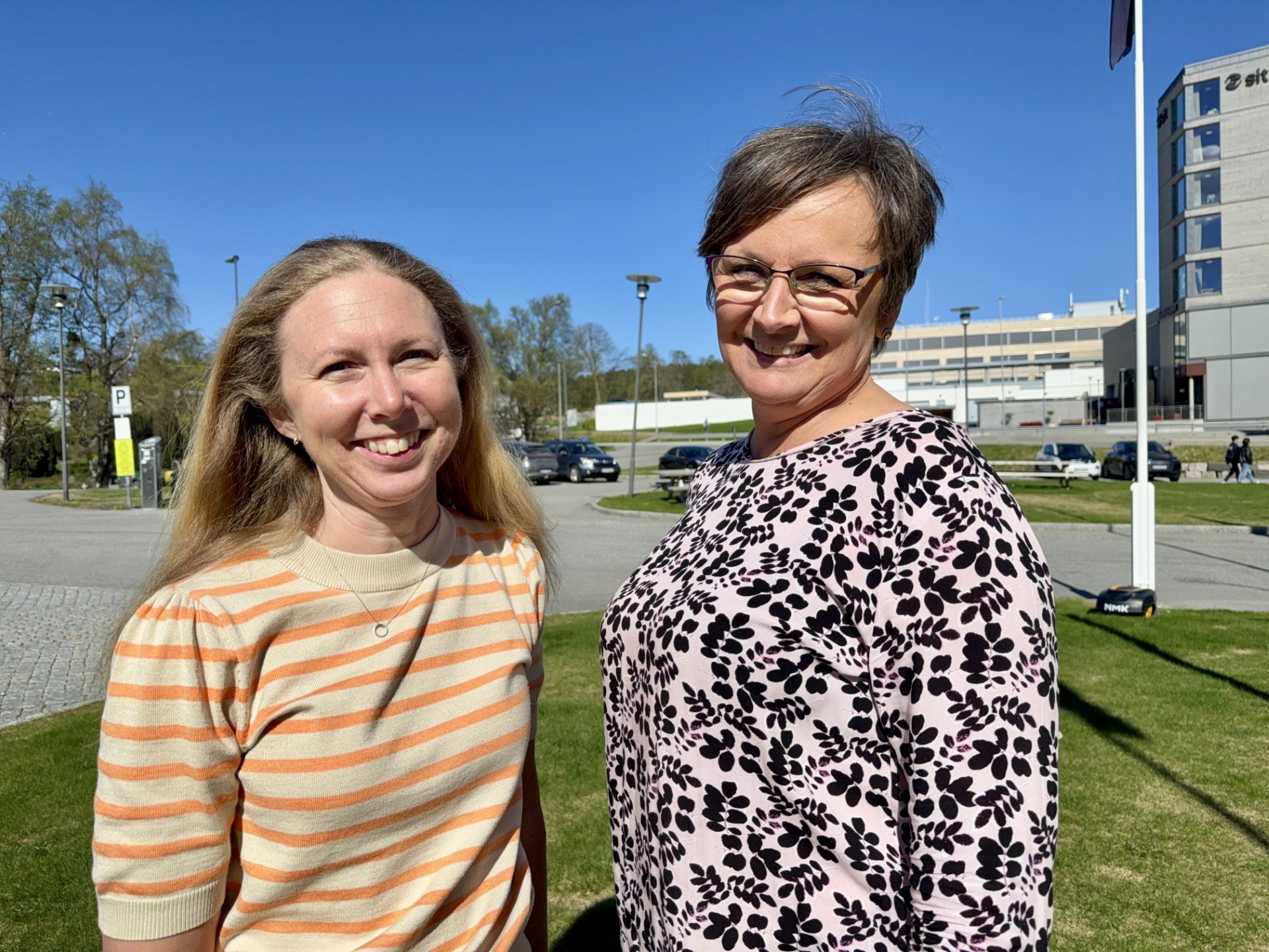 A person wearing a virtual reality headset stands in front of multiple screens, engaged in a digital experience.