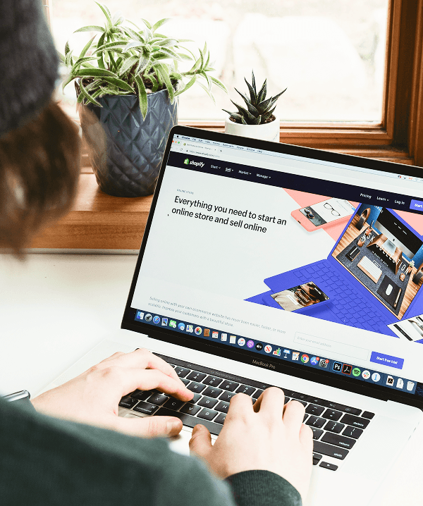 A man with long hair is working on a computer.