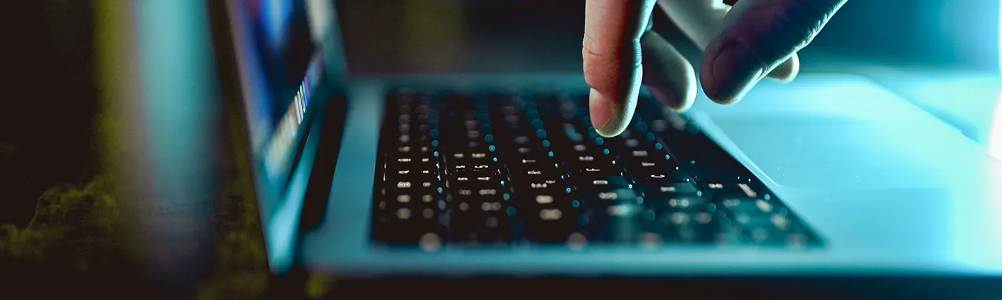 Close up image of a website user typing on a laptop keyboard