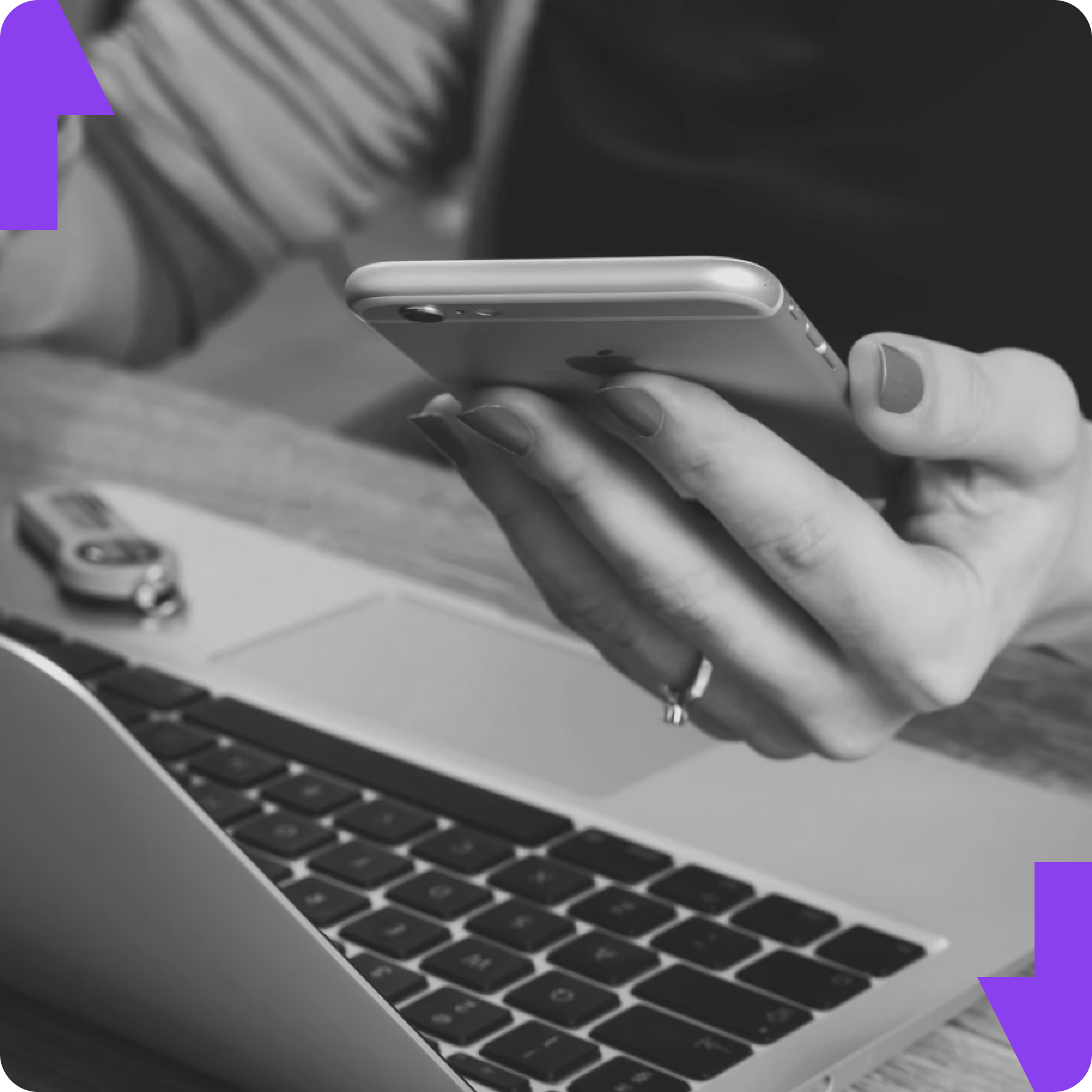 Woman holding cellphone in front of a laptop