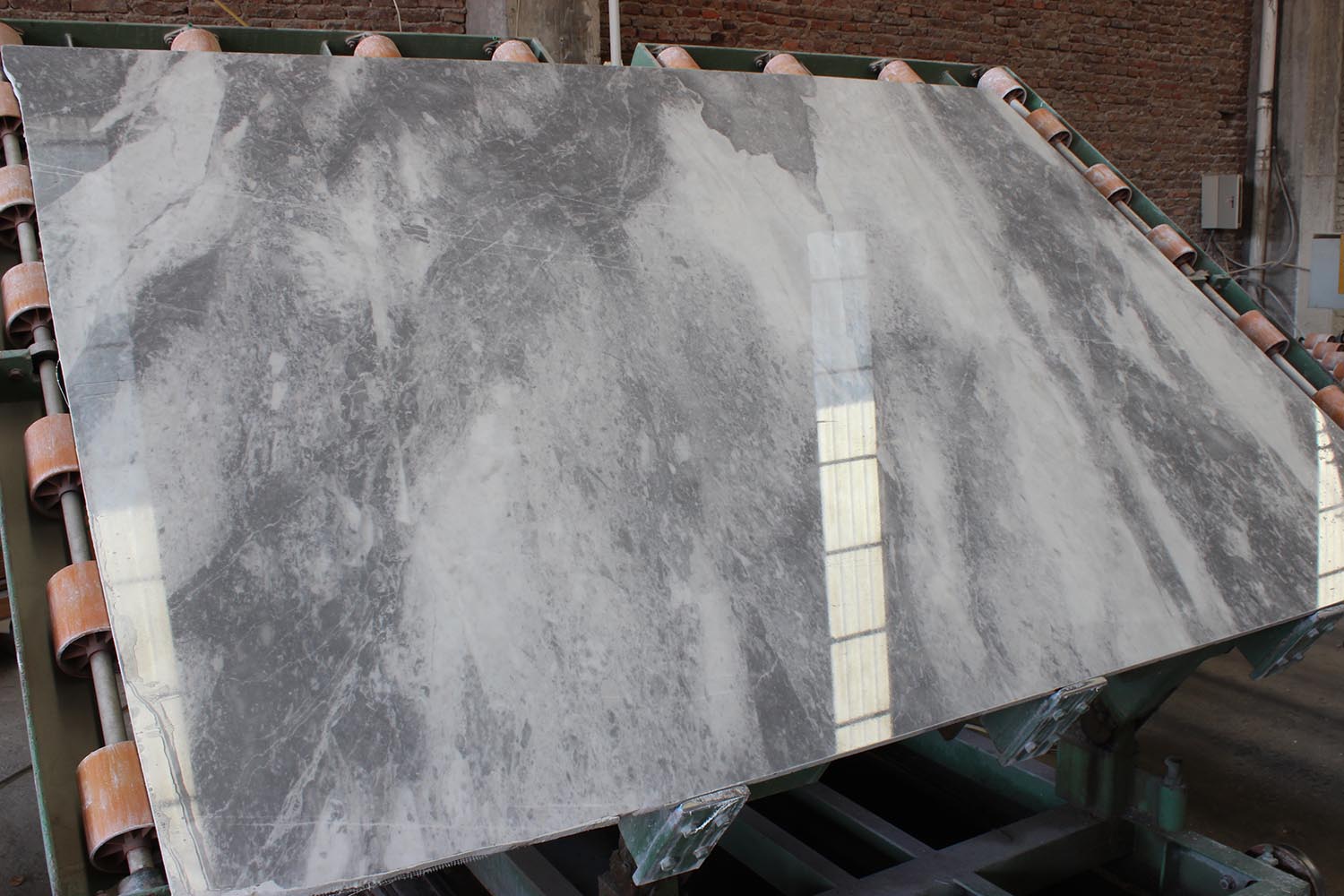 A large polished stone slab displayed on a conveyor belt after processing by the Fully-Automatic Polishing Machine, showcasing the high-quality finish.