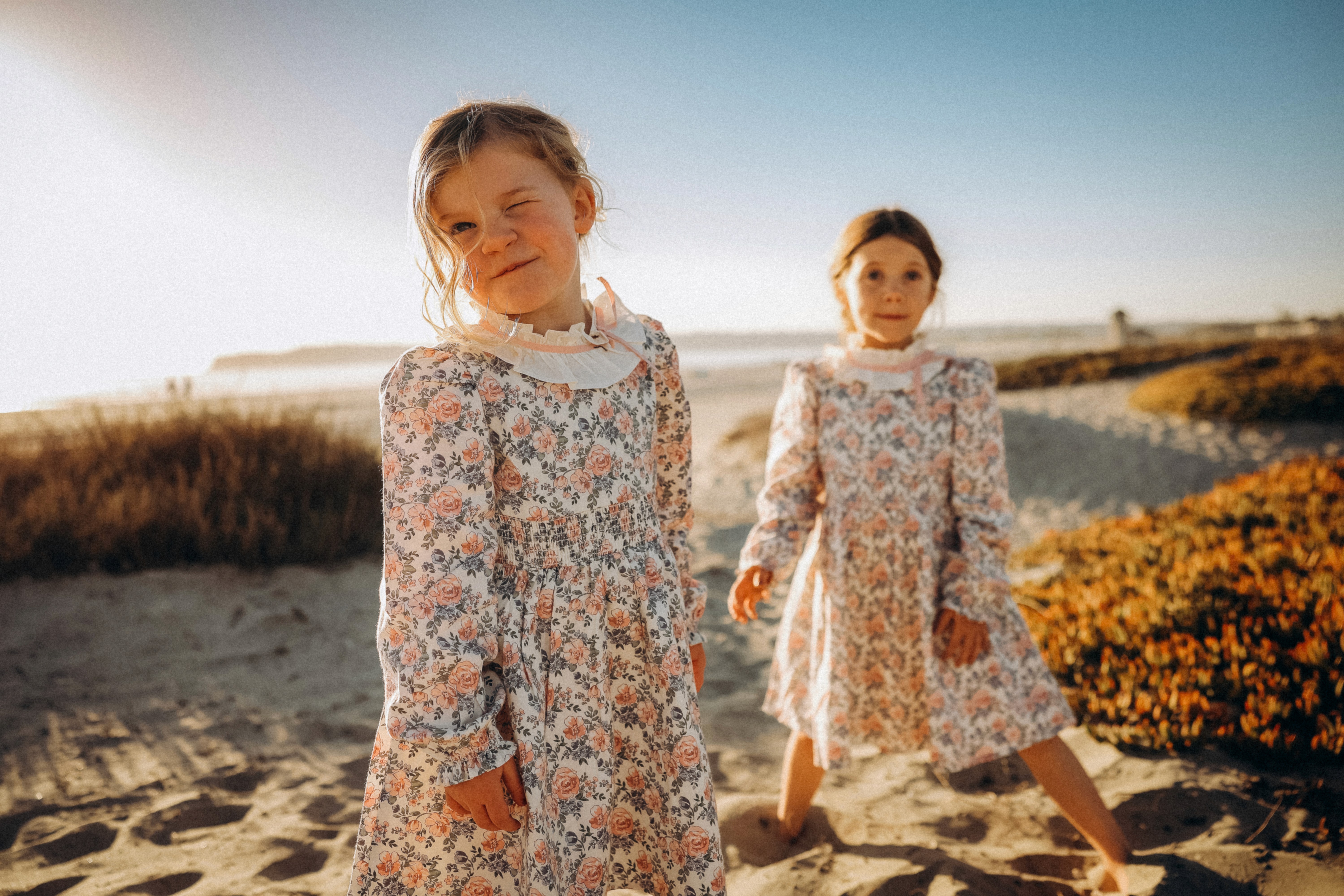 Kids exploring the beach at sunset, dressed in matching outfits for a family session.