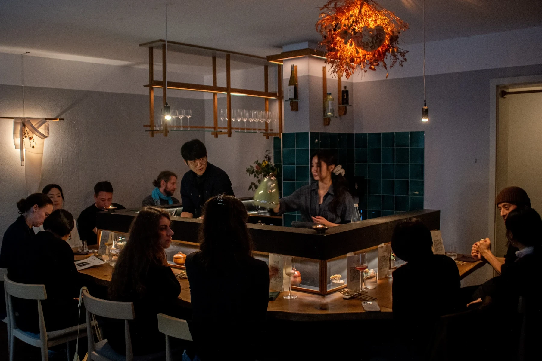 At Choi in Berlin, two people behind a counter serve drinks to a small group of diners