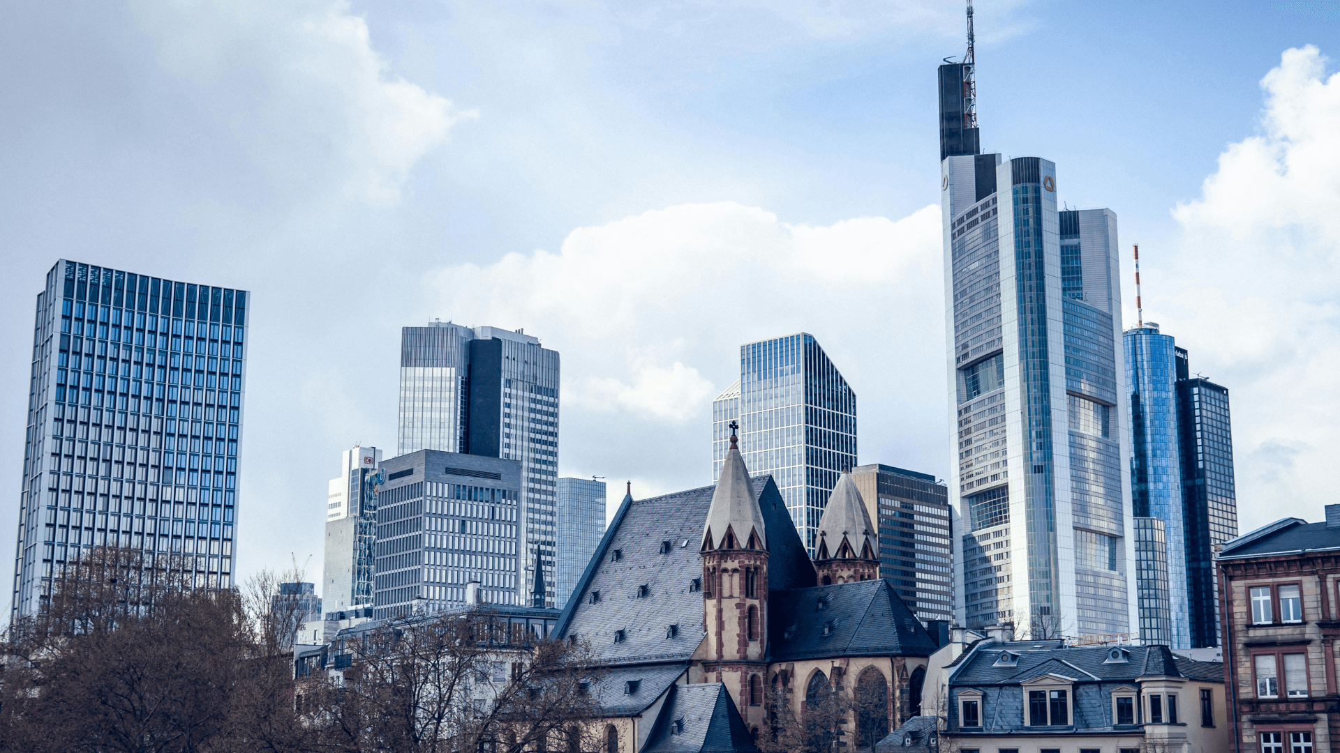 Skyline of Frankfurt with modern skyscrapers and historic architecture, highlighting the city's mix of tradition and innovation.