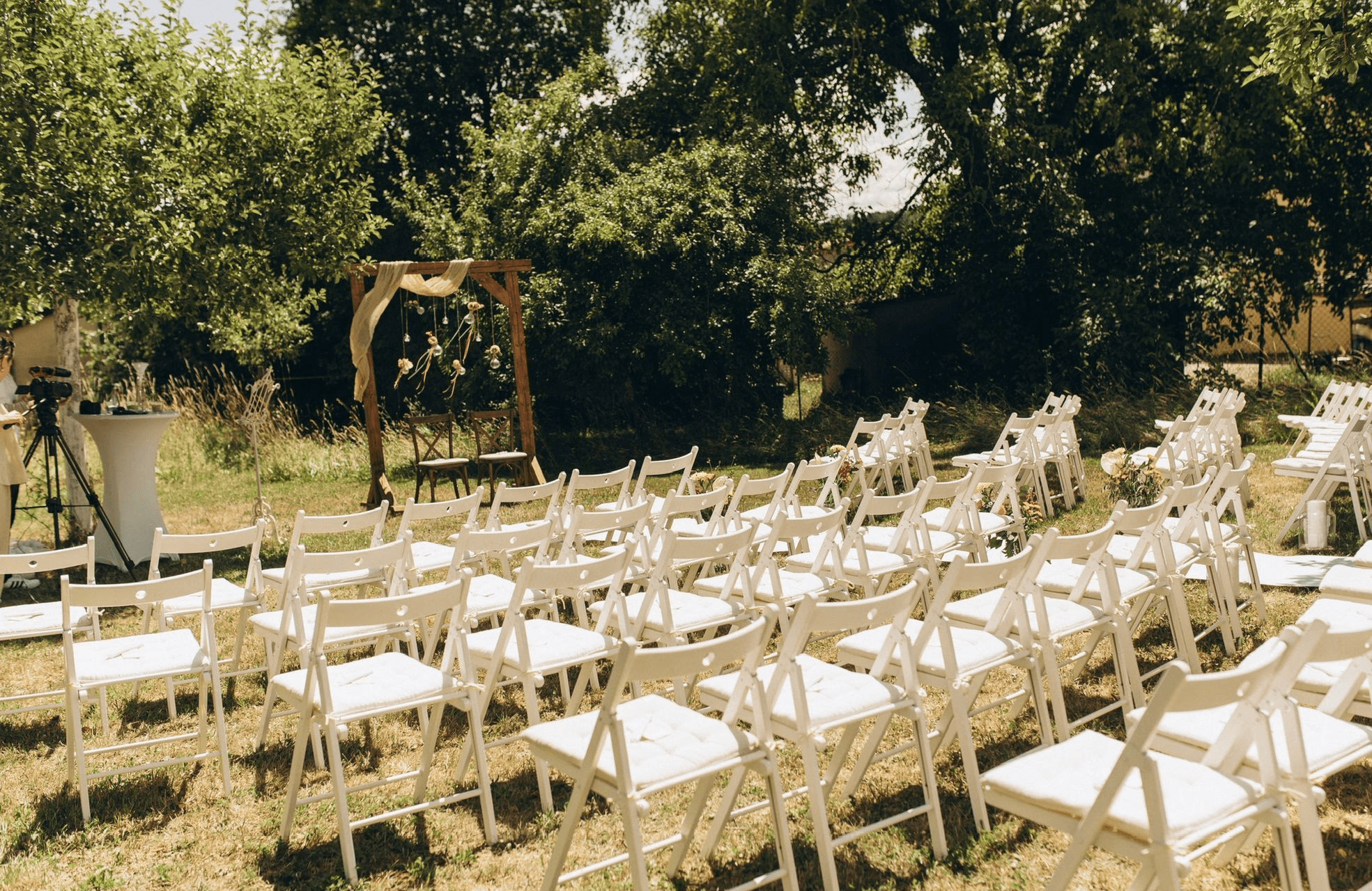 Weiße Klappstühle im Verleih für eine freie Trauung im Freien – ideales Outdoor-Equipment für Hochzeiten von fruchtbar mobil.