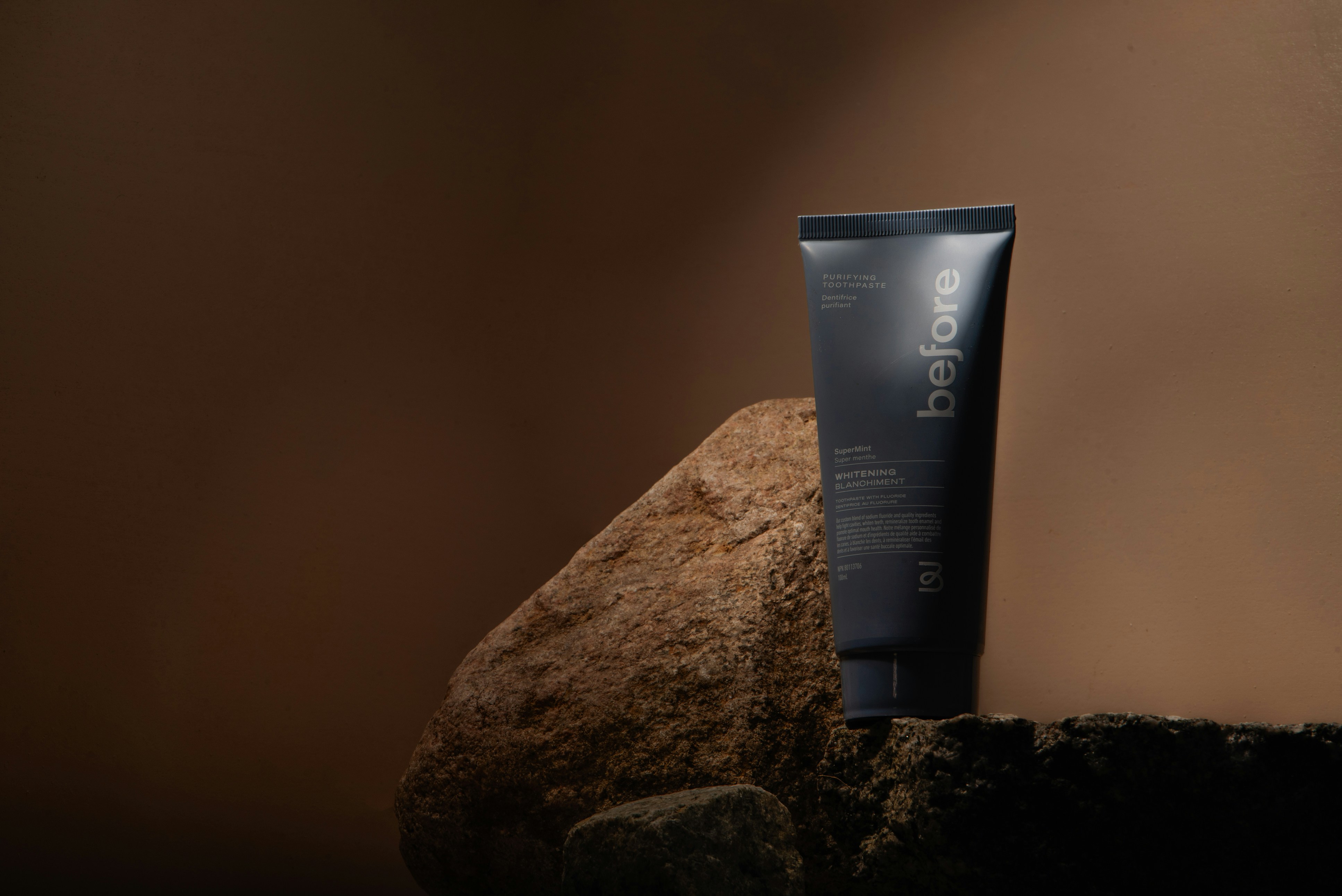 a tube of lotion sitting on top of a rock