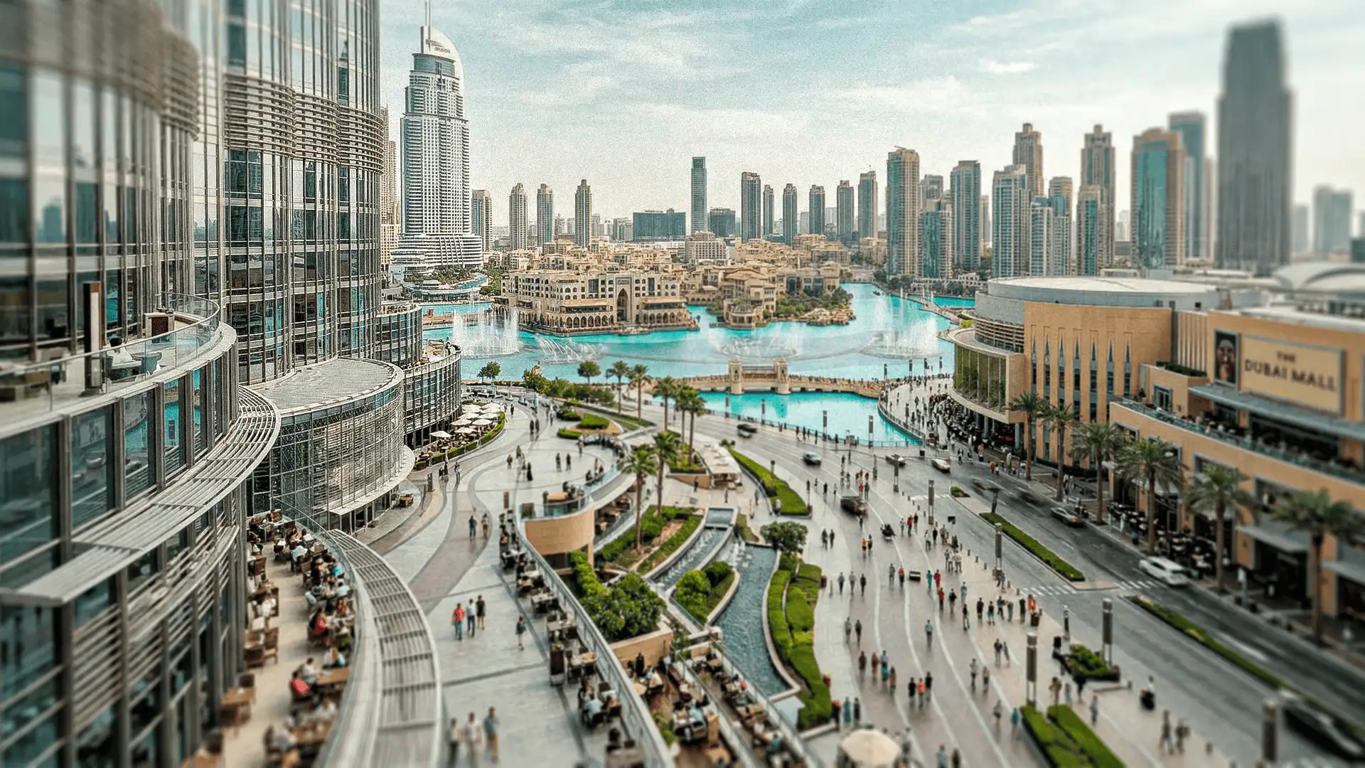 Centro de Dubái con rascacielos modernos, el Dubai Mall, fuentes y espacios peatonales en un entorno urbano de lujo.