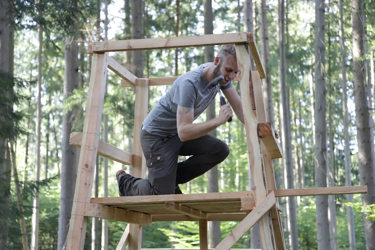 Felix Bayrle beim Bau eines Hochsitzes aus Holz im Wald
