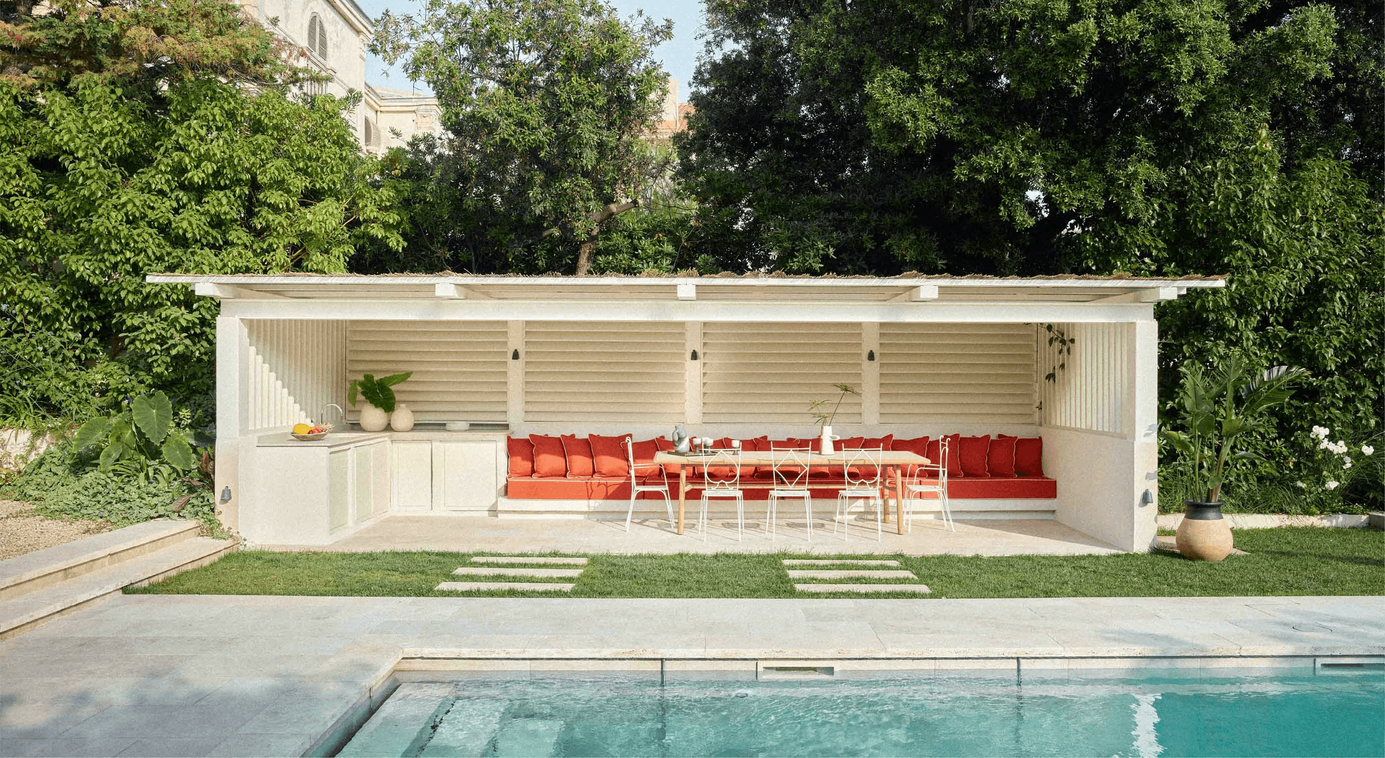 Modern house featuring expansive glass walls and windows, blending indoor and outdoor living spaces seamlessly.