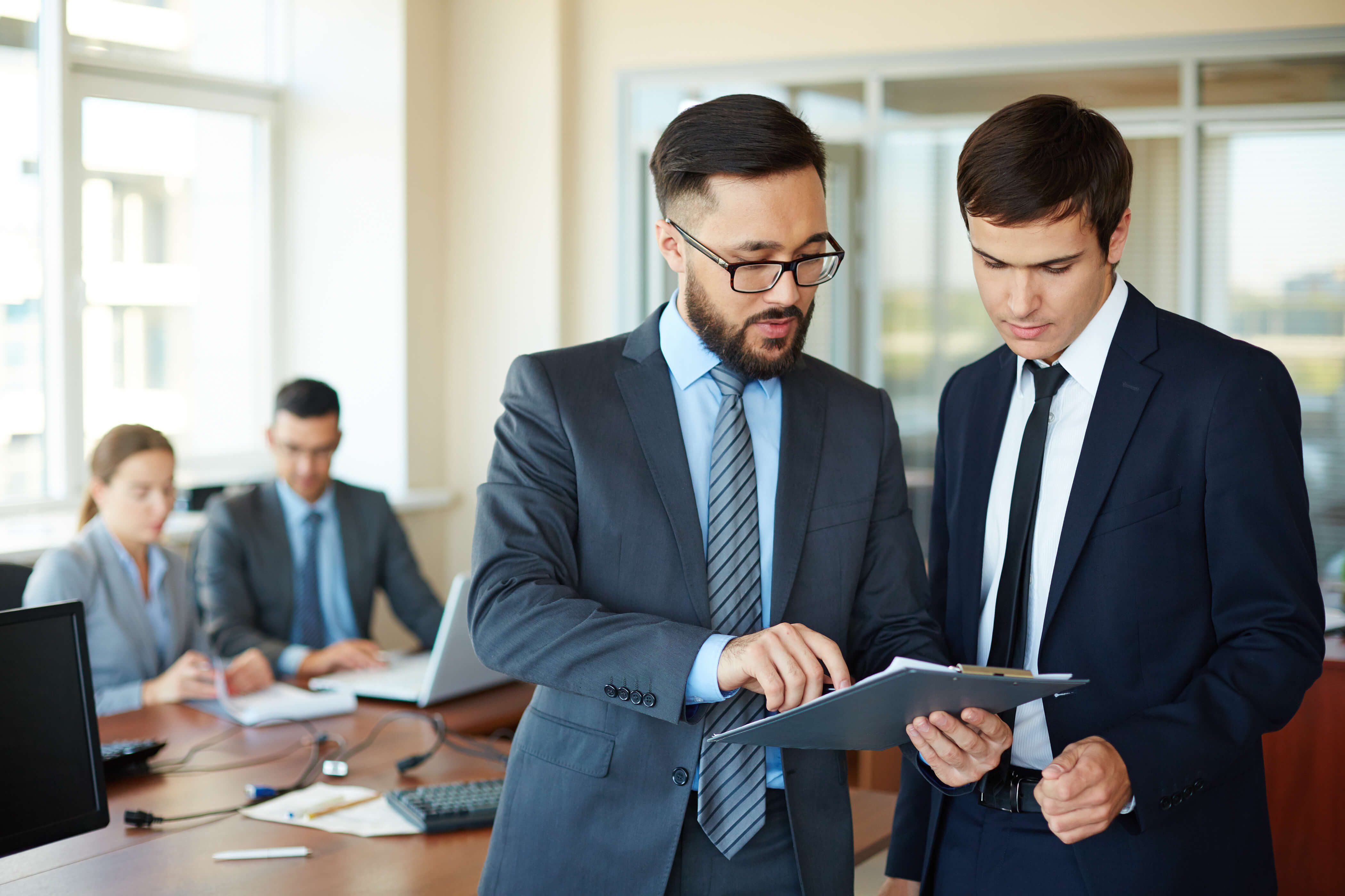 Men in suits looking at a tablet