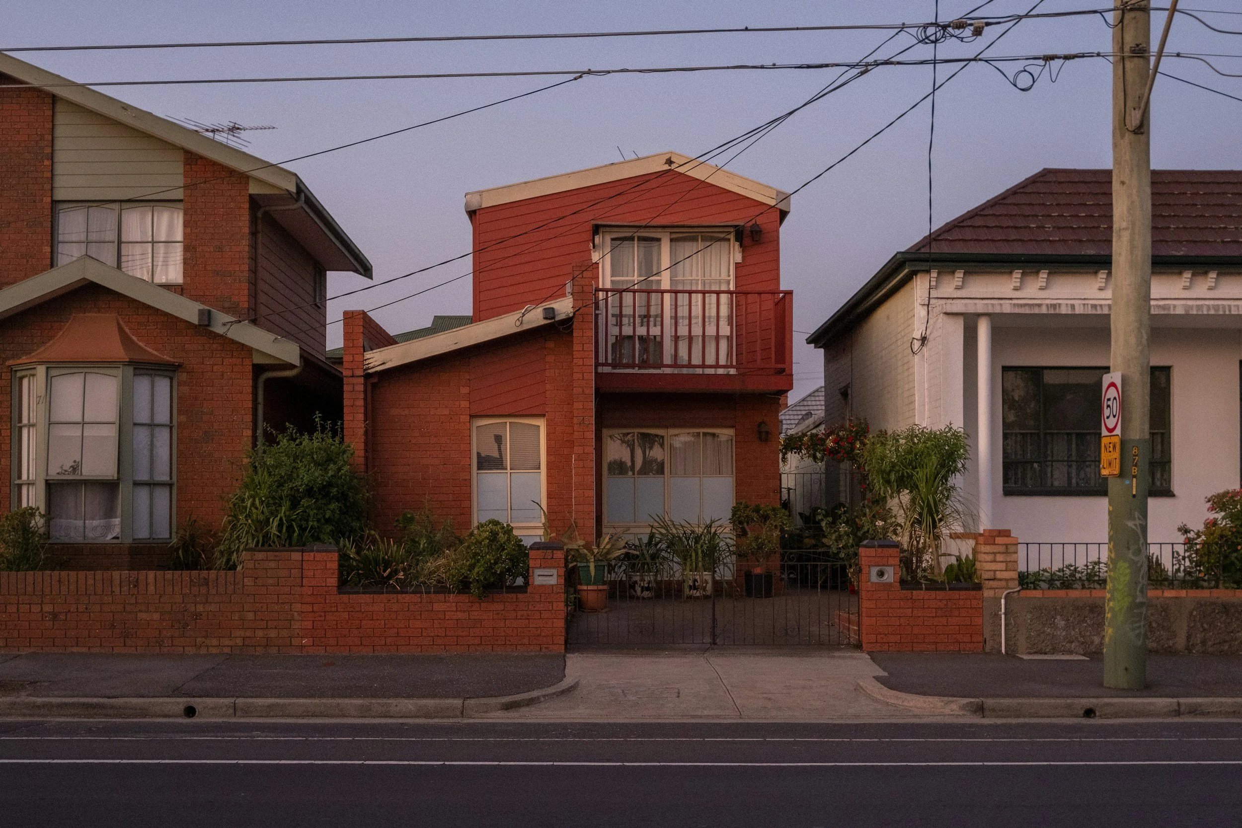 Red brick house on a suburban street at dusk