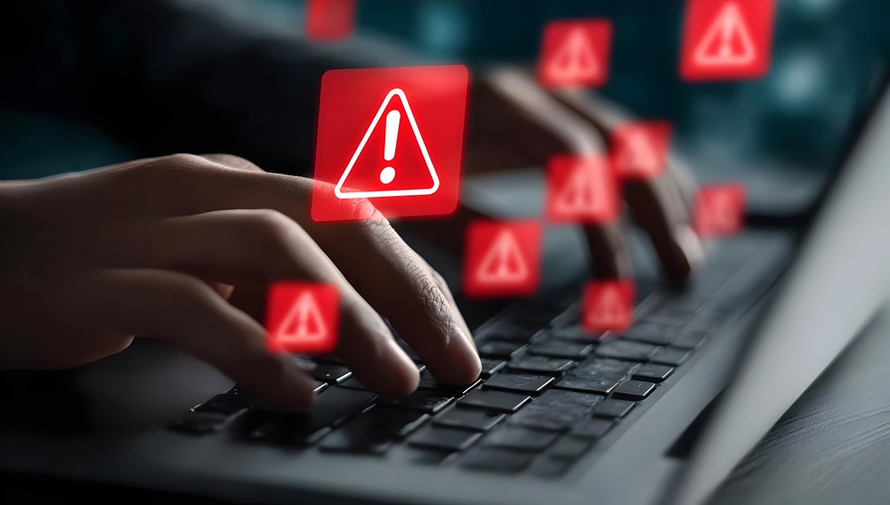 Red digital warning symbol glowing on a circuit board interface, representing active ransomware exploitation of the VMware ESXi CVE 2025 22225 vulnerability and hypervisor compromise.