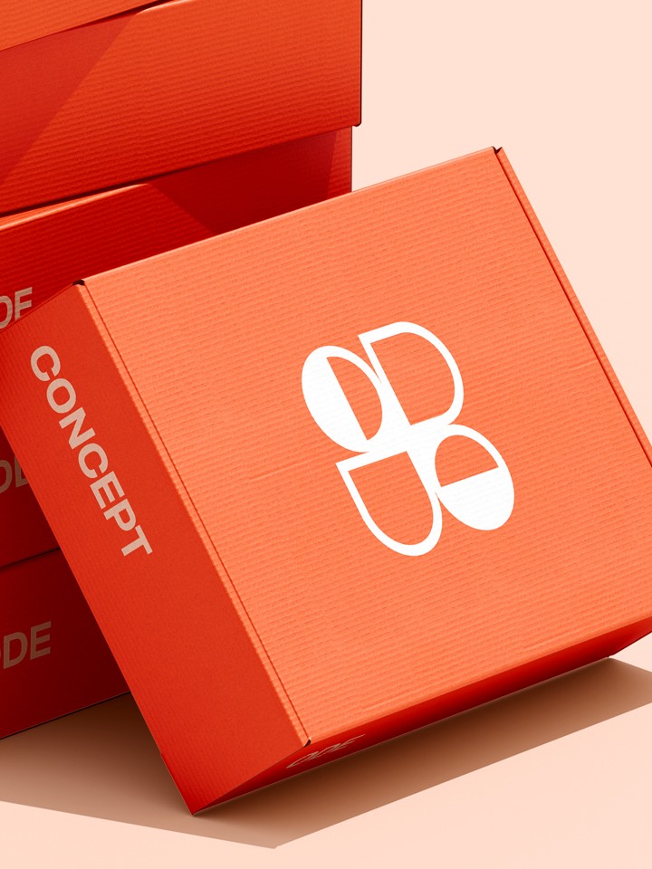 Close-up view of an angled red-orange “CONCEPT” shipping box showing the white ODE logo on its lid and the word “CONCEPT” along its side, against a pale peach background.