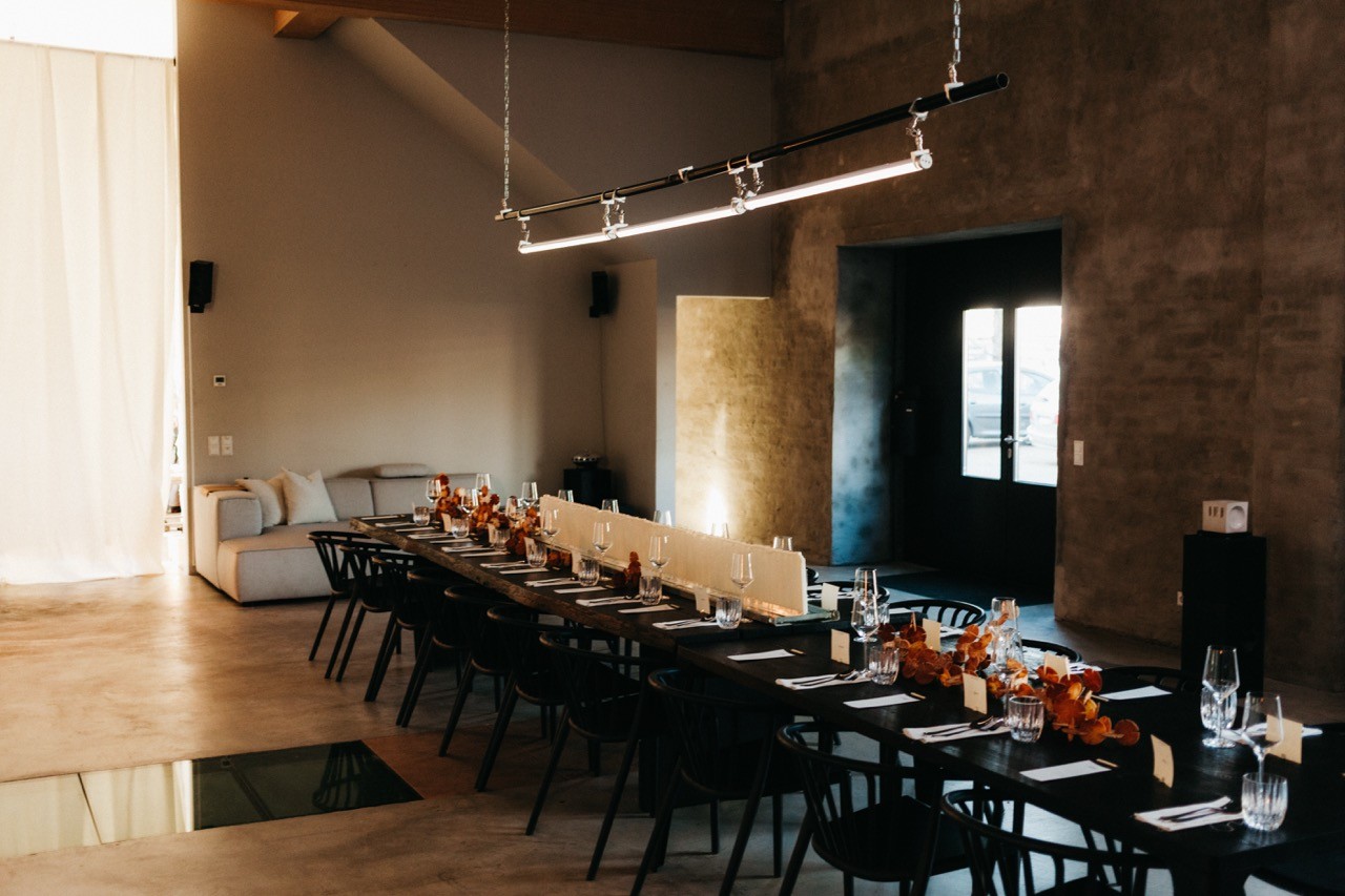 A close-up of a luxurious skincare jar with a gold lid, set against a soft, neutral background with gentle shadows.