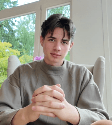 An asian person in a dark area with a sunlight on him