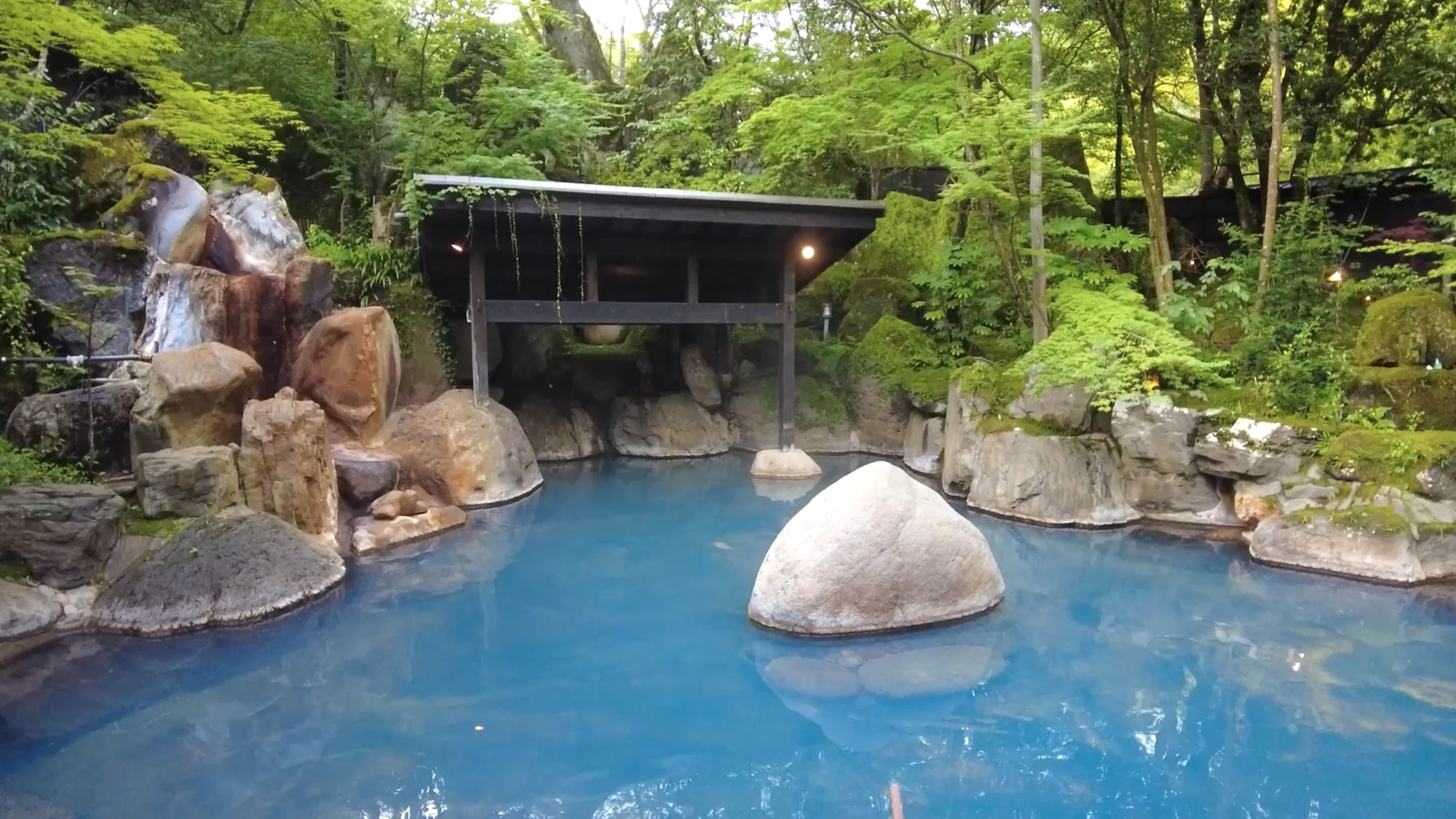 An open-air bath built around a large boulder in Kurokawa