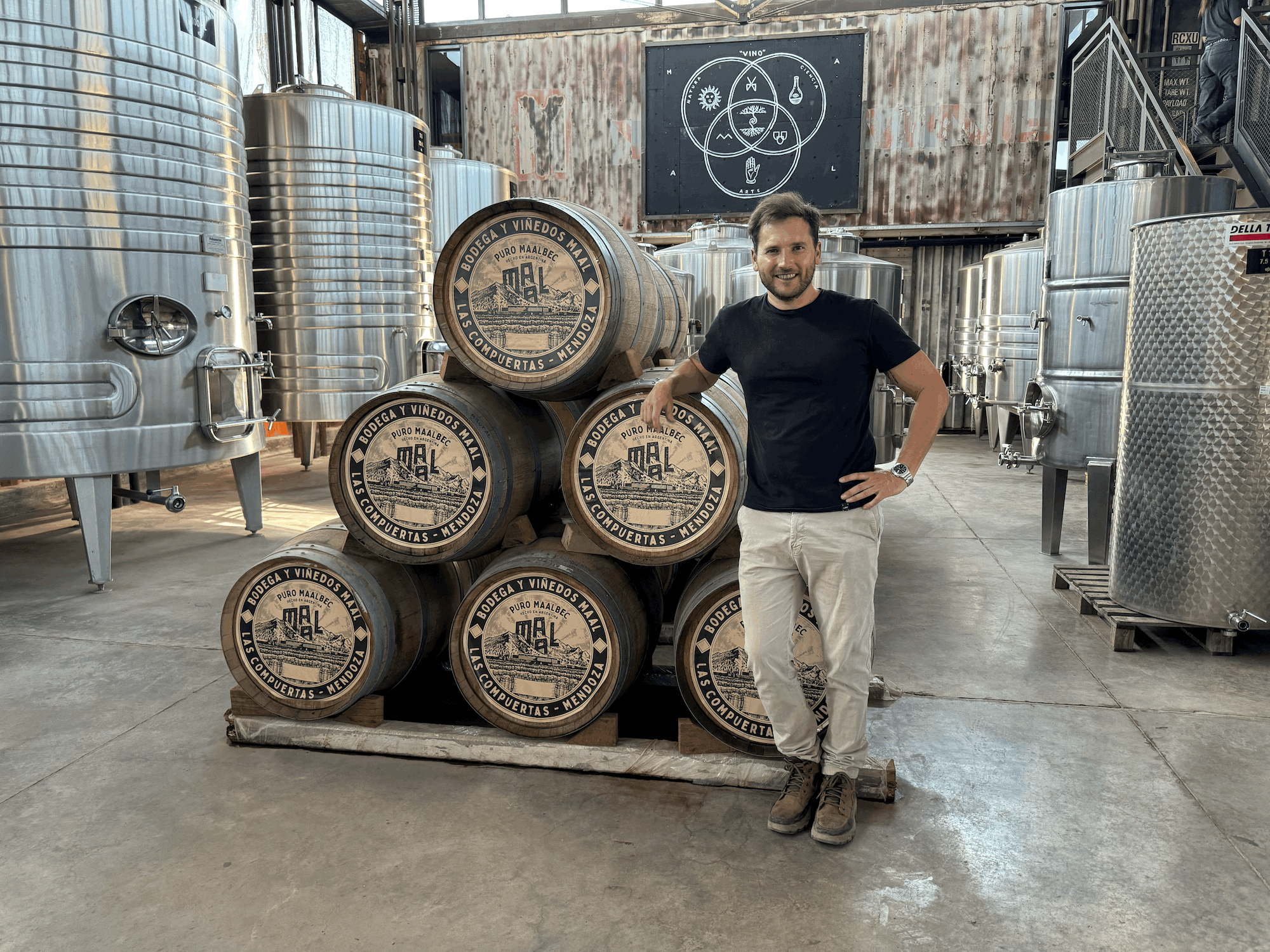 MAAL winemaker Facundo Azzoni standing beside barrels and stainless-steel tanks in the Mendoza winery