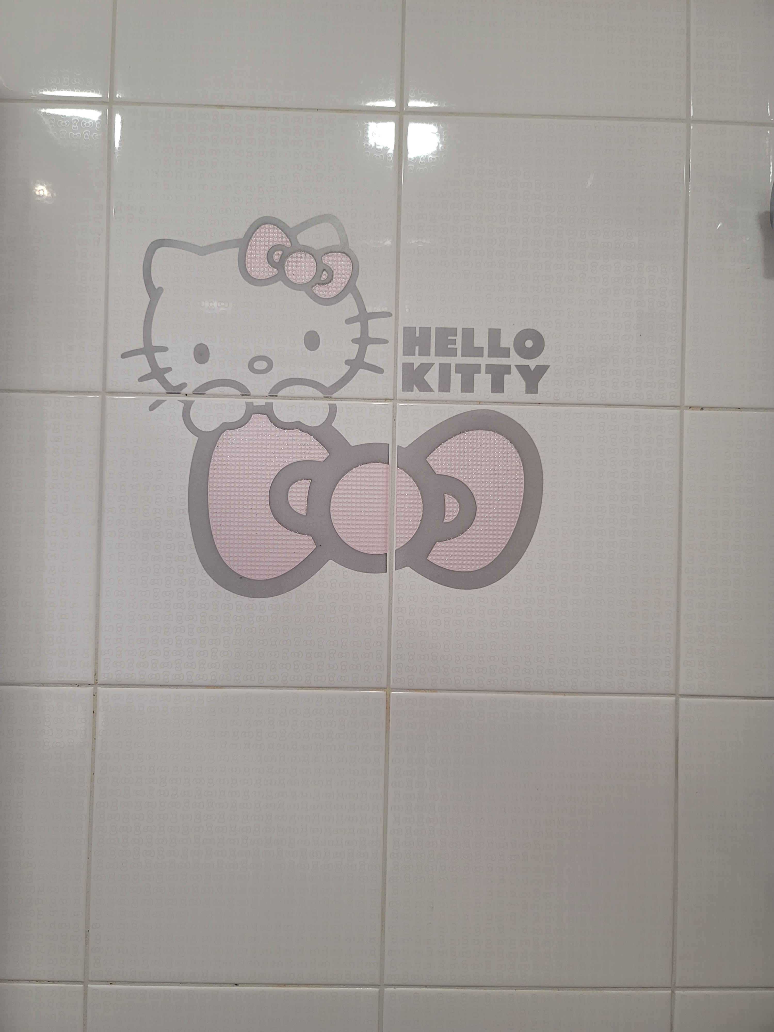 Detailed Hello Kitty motif on white and pink wall tiles illustrating bathroom design quirky elements at Hoi Tat Estate.