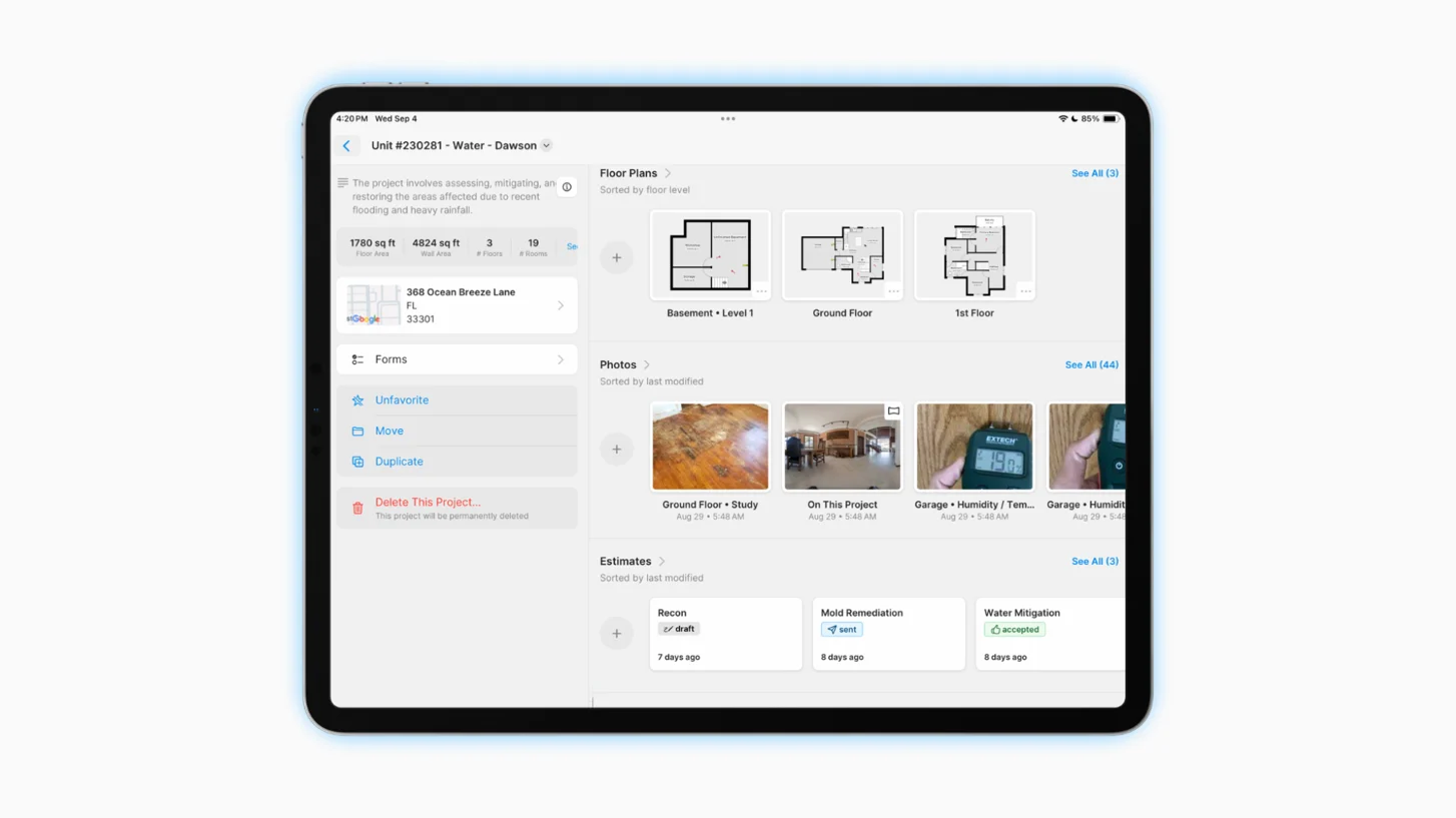 a restorer working with his tablet in front of a house