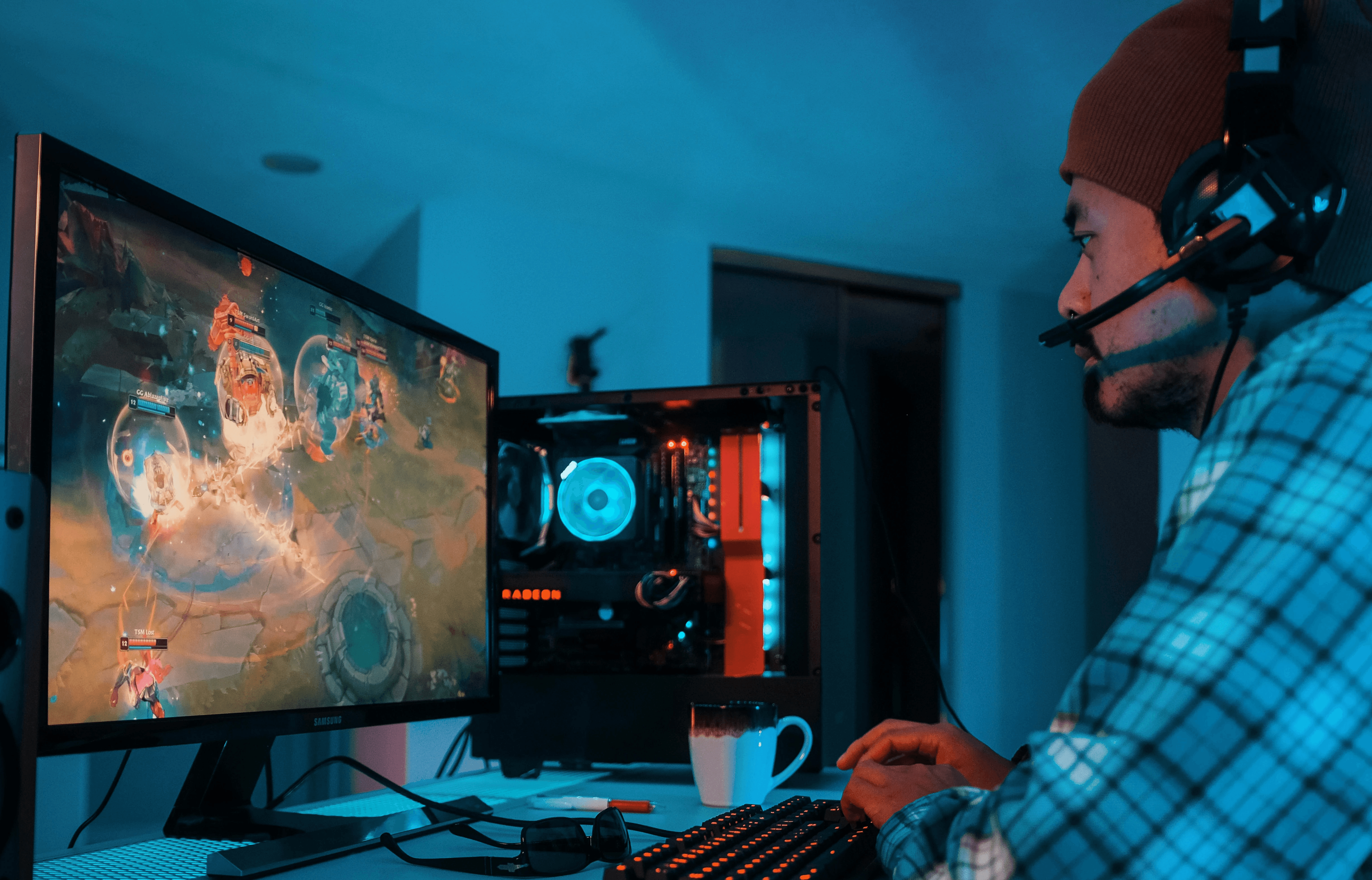 a man wearing headphones and sitting at a desk with a computer