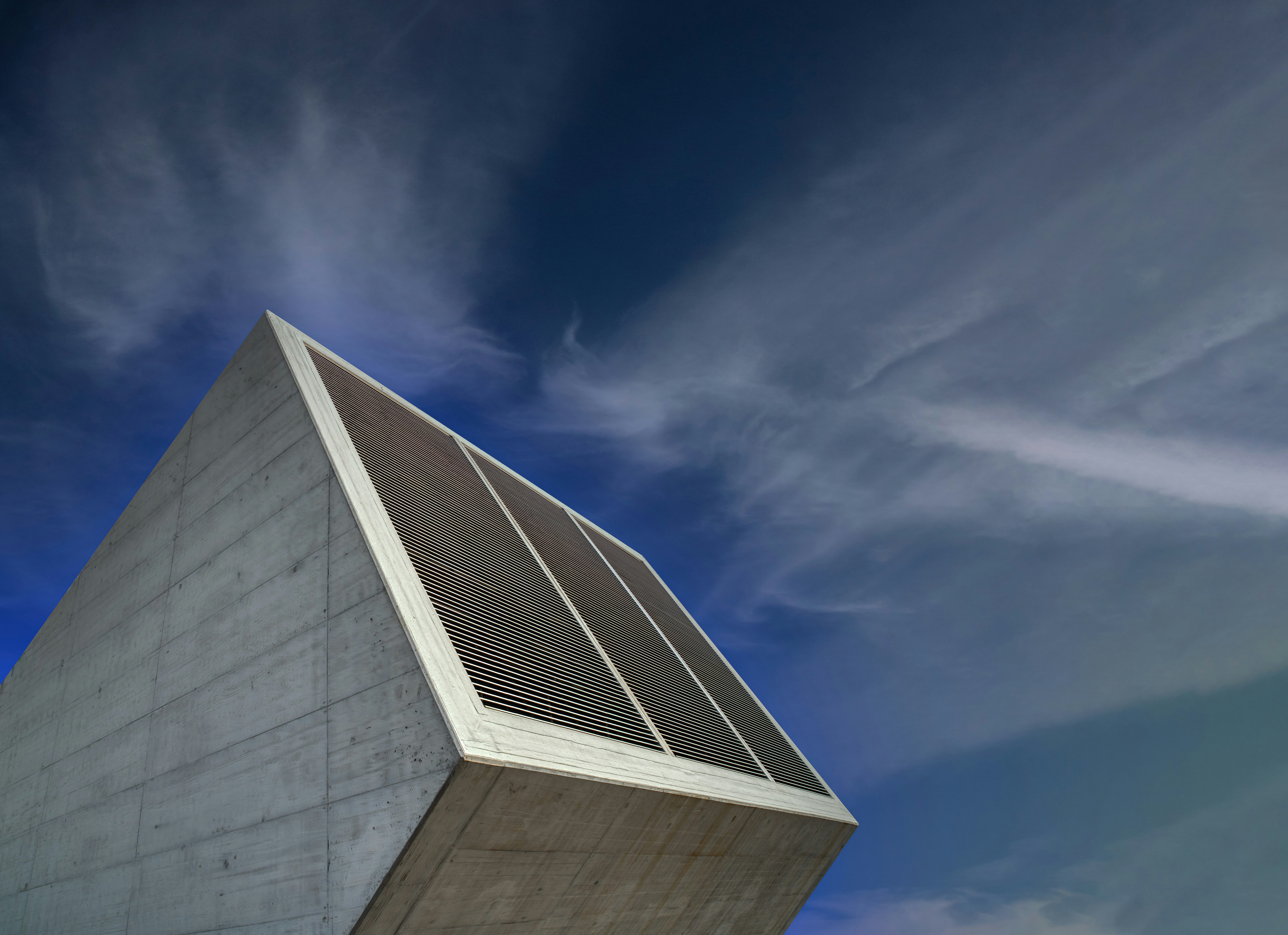 a tall white building sitting under a blue sky