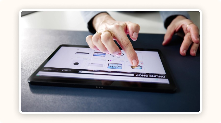 Hand browsing an online store on a tablet