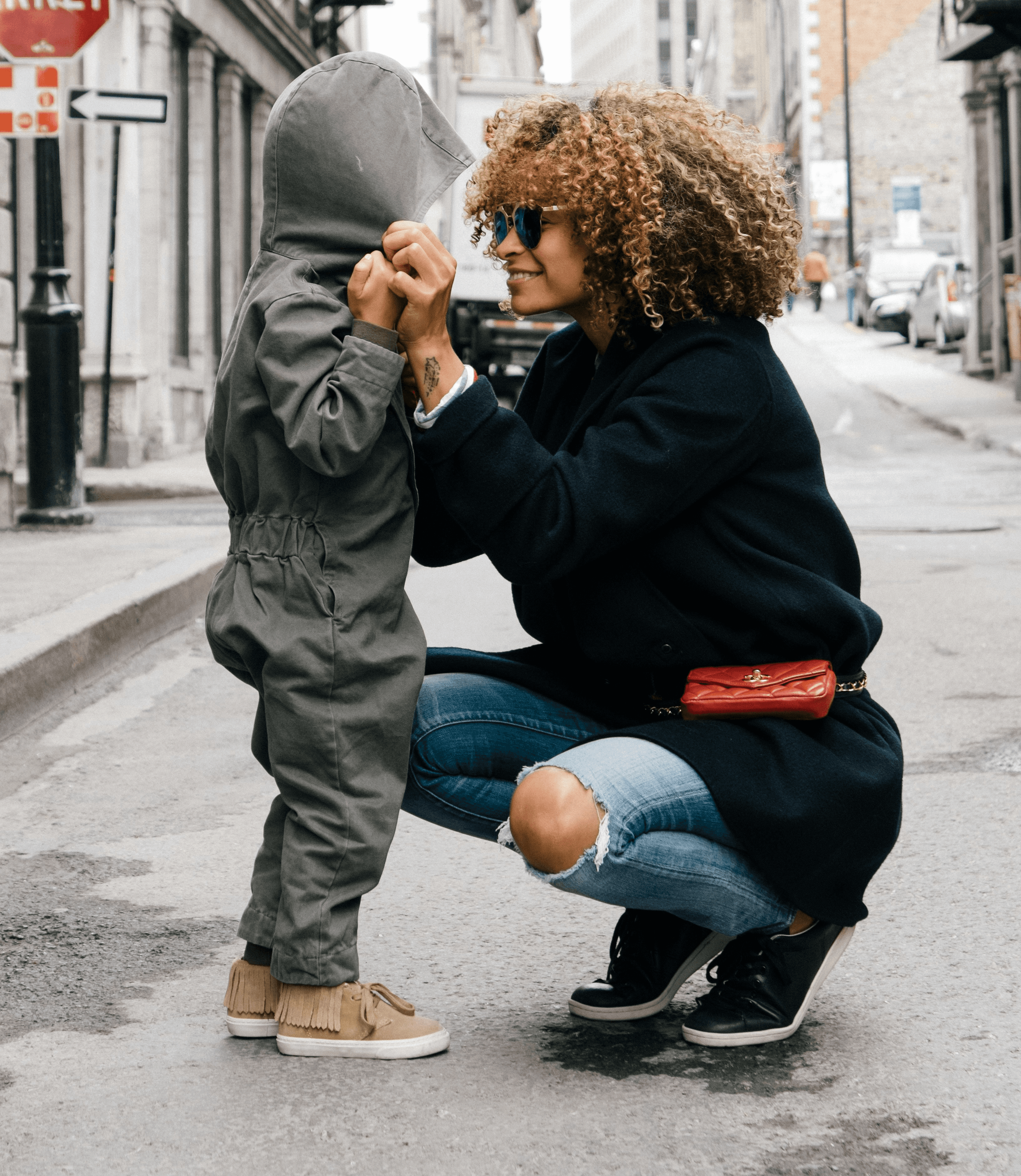 woman holding kid at the street