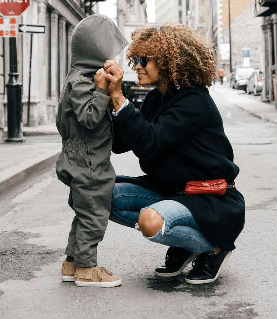 woman holding kid at the street