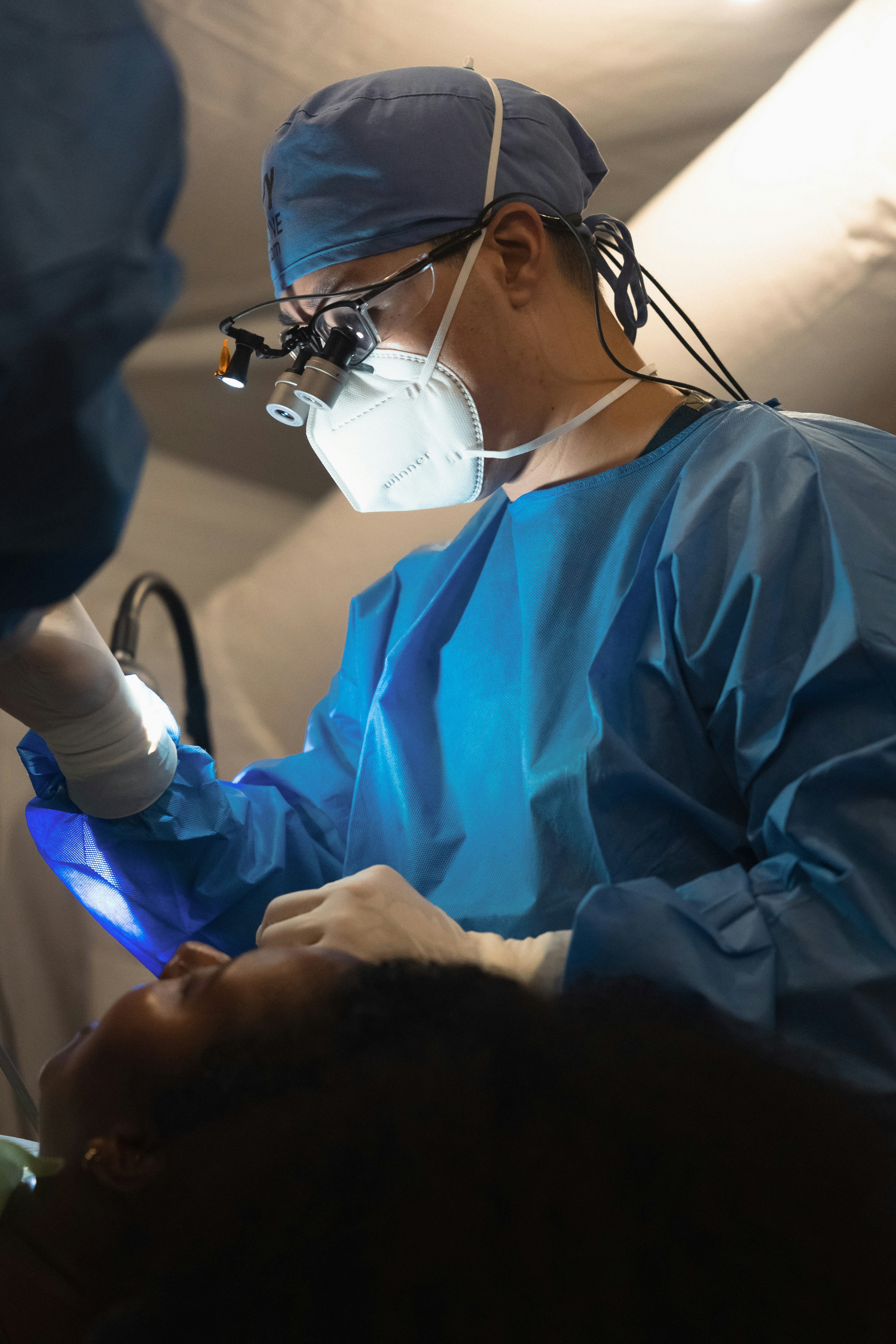 Surgeon performing a medical procedure on a patient.