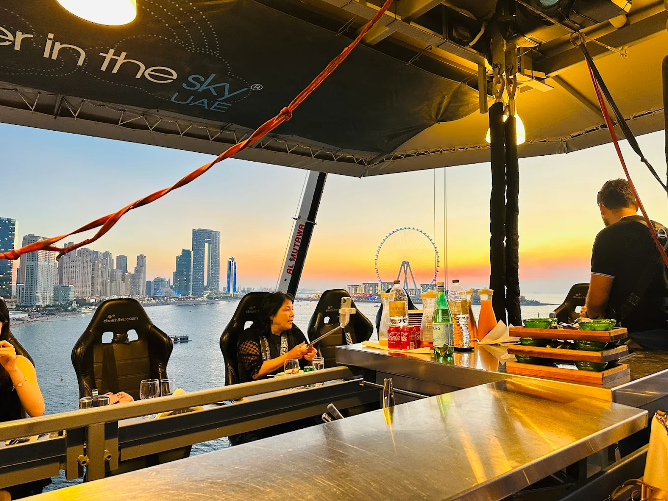 People are hoisted above the ground while dining in Dinner in the Sky, a famous restaurant location in Dubai.