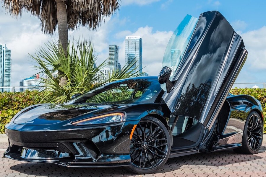 A luxury McLaren sports car parked in Miami, highlighting its aerodynamic design and vibrant color, perfect for exotic car rentals in the city.