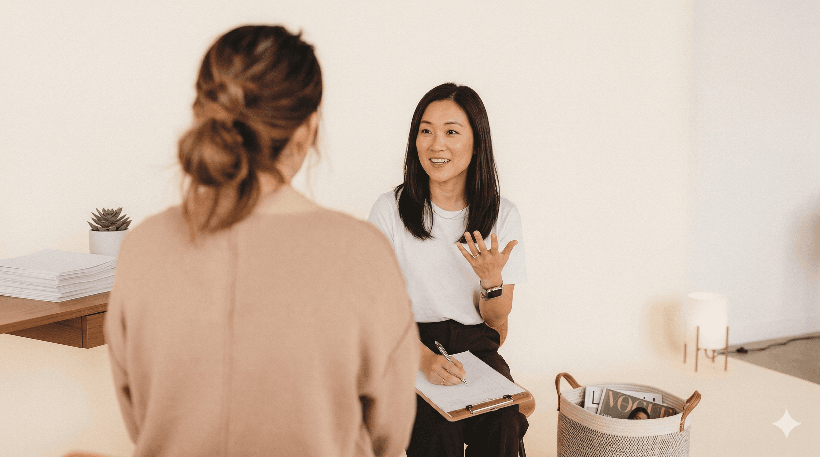 Two people painting in a bright, cluttered art studio.