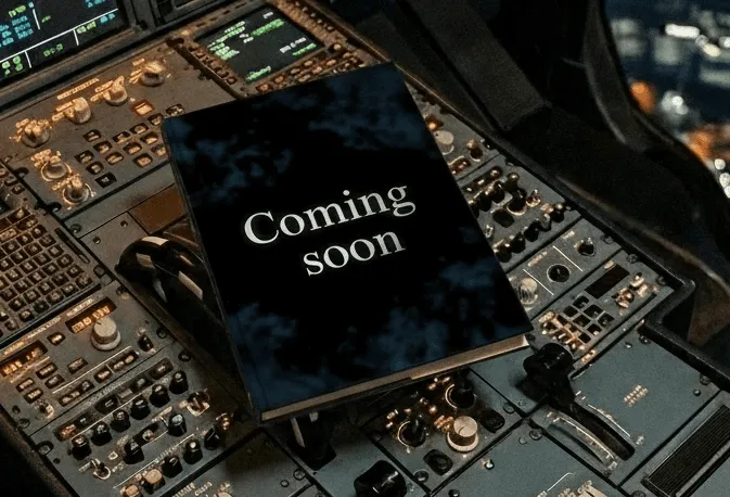 Airplane cockpit control panel at night with a book labeled “Coming soon” placed on the controls.
