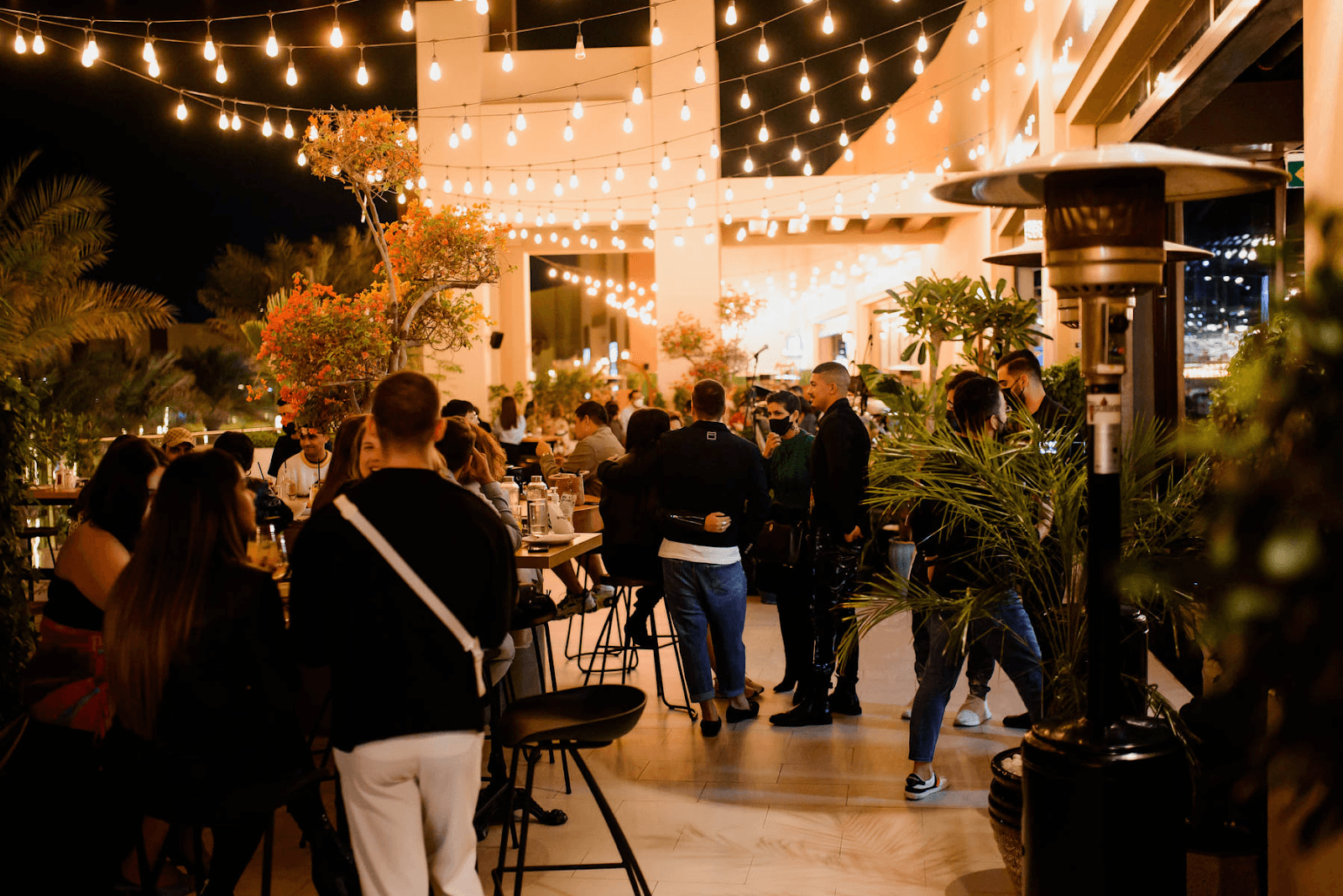 Guests socialising and dining in an outdoor terrace at a social restaurant.
