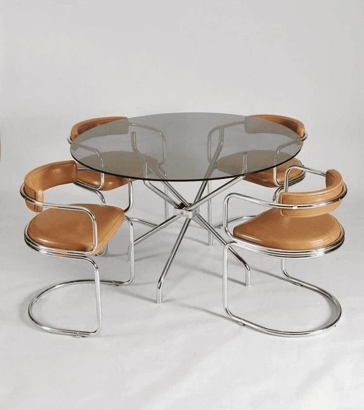 Una mesa de comedor moderna con una elegante base metálica y sillas de madera curvadas.