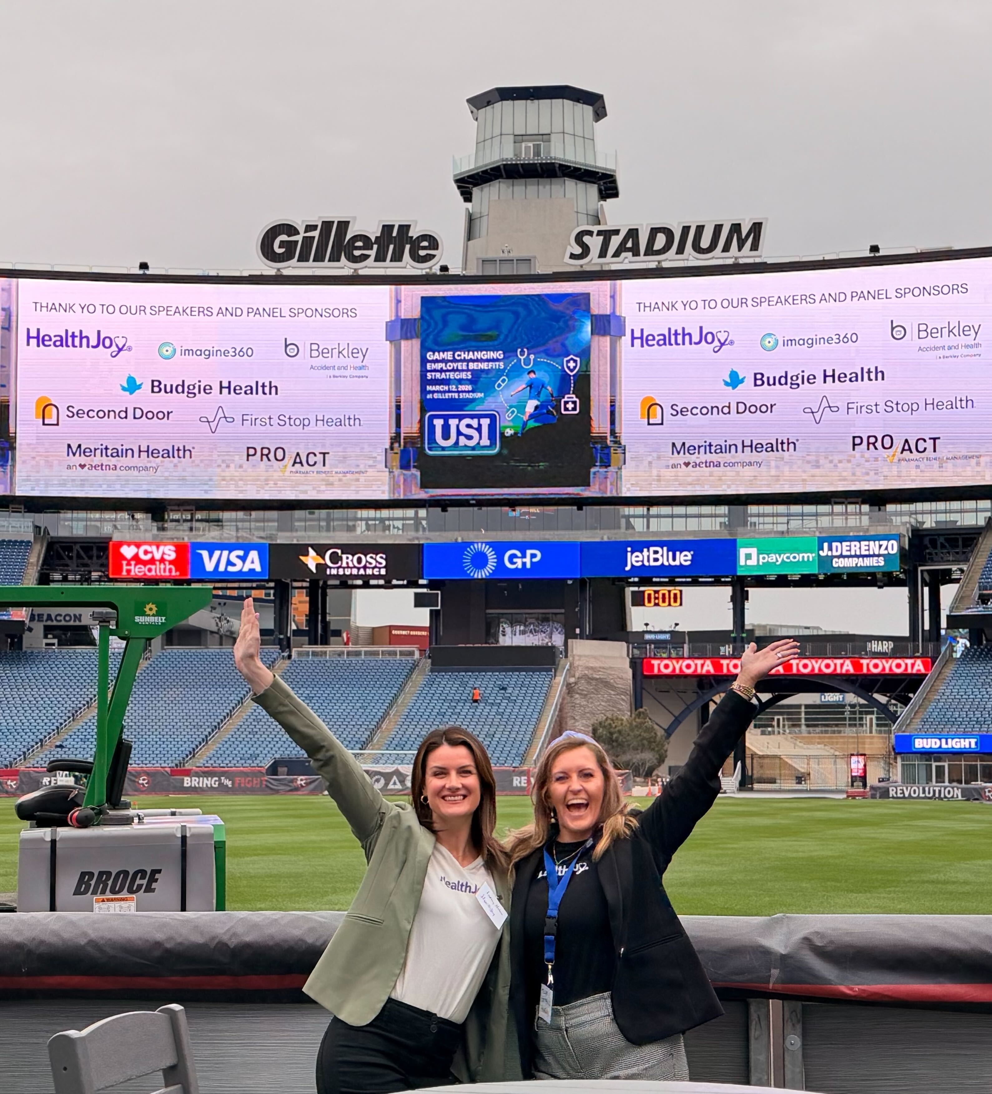HealthJoy team member at Gillette Stadium with a HealthJoy ad on the stadium screen.