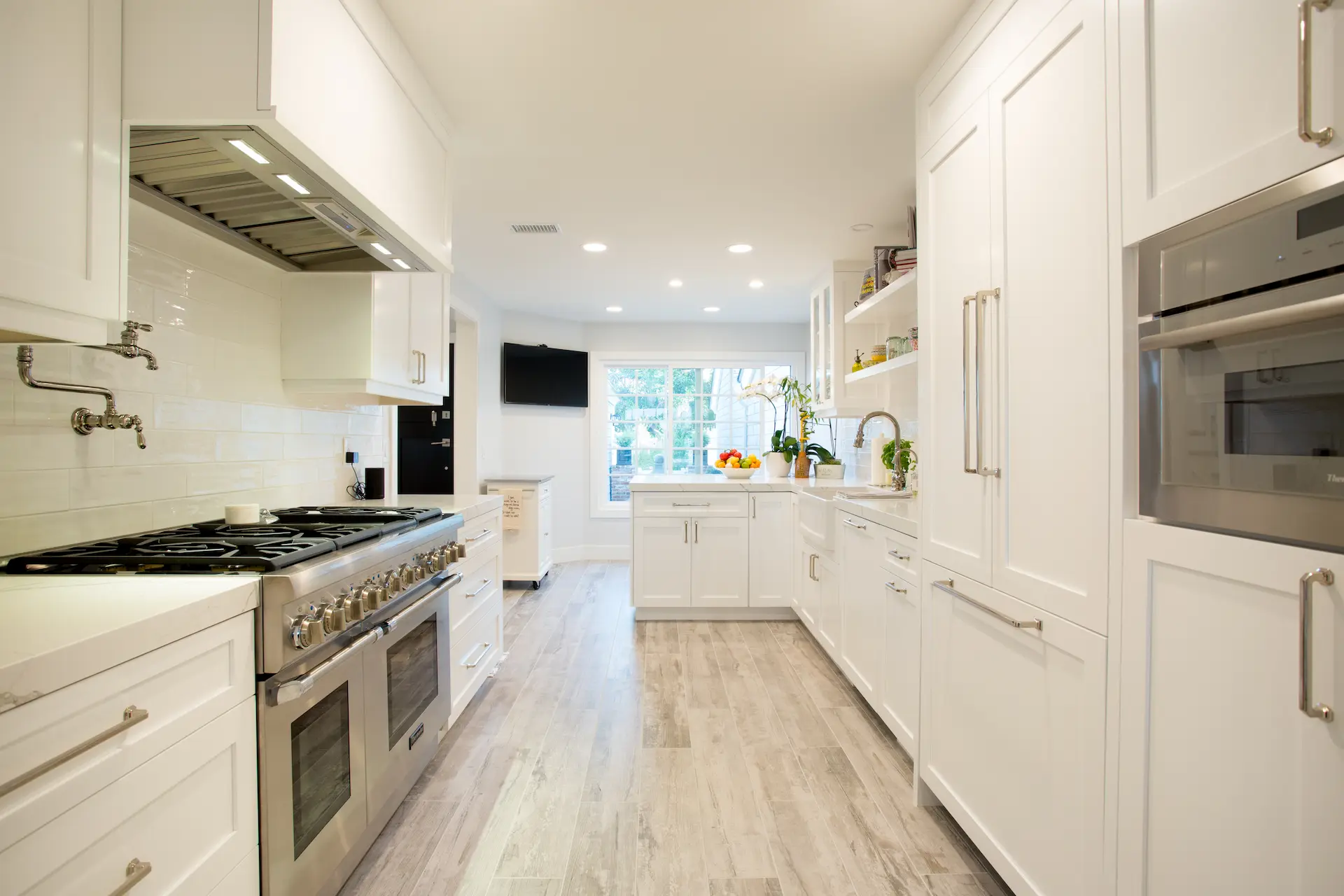 Spacious white kitchen, ample light, double oven, floating shelves, Dana Point Cape Cod remodel, photo by Chris Darnall.