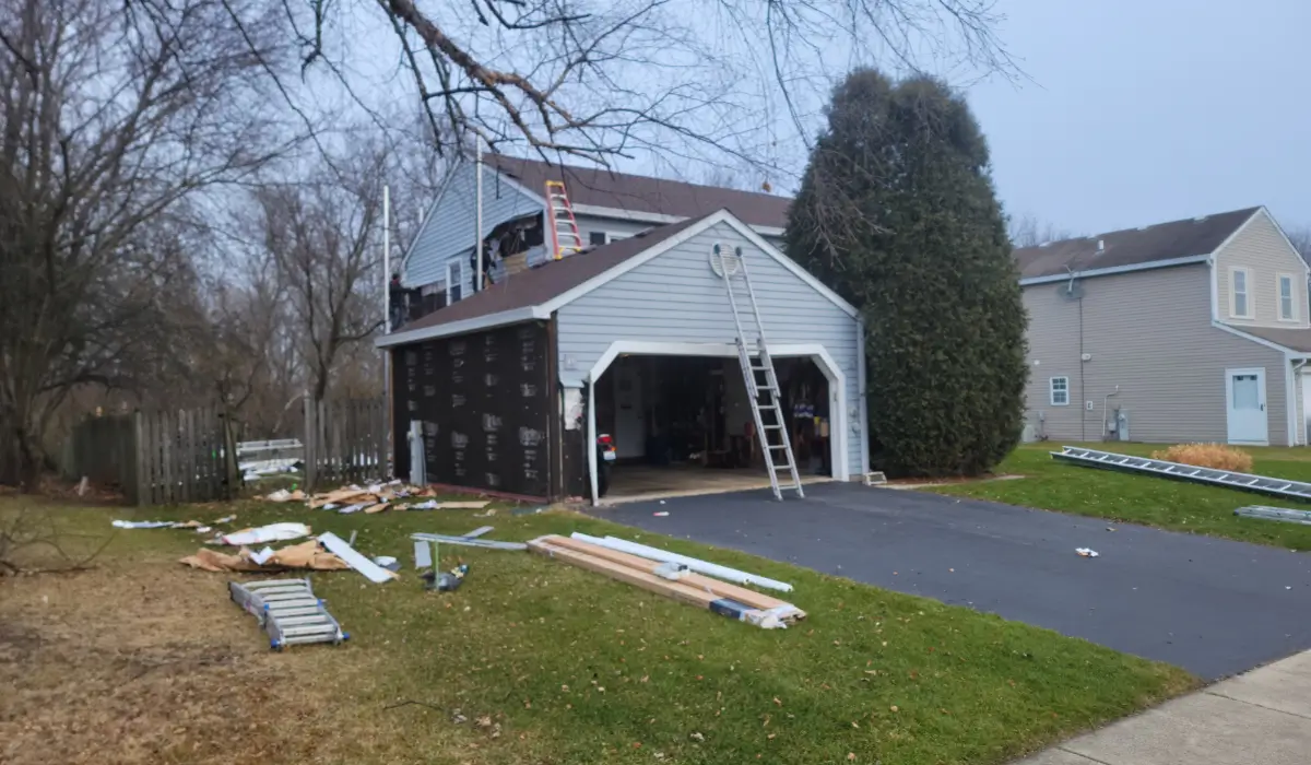 Siding replacement in IL shown during winter with residential garage exterior prepared for installation.