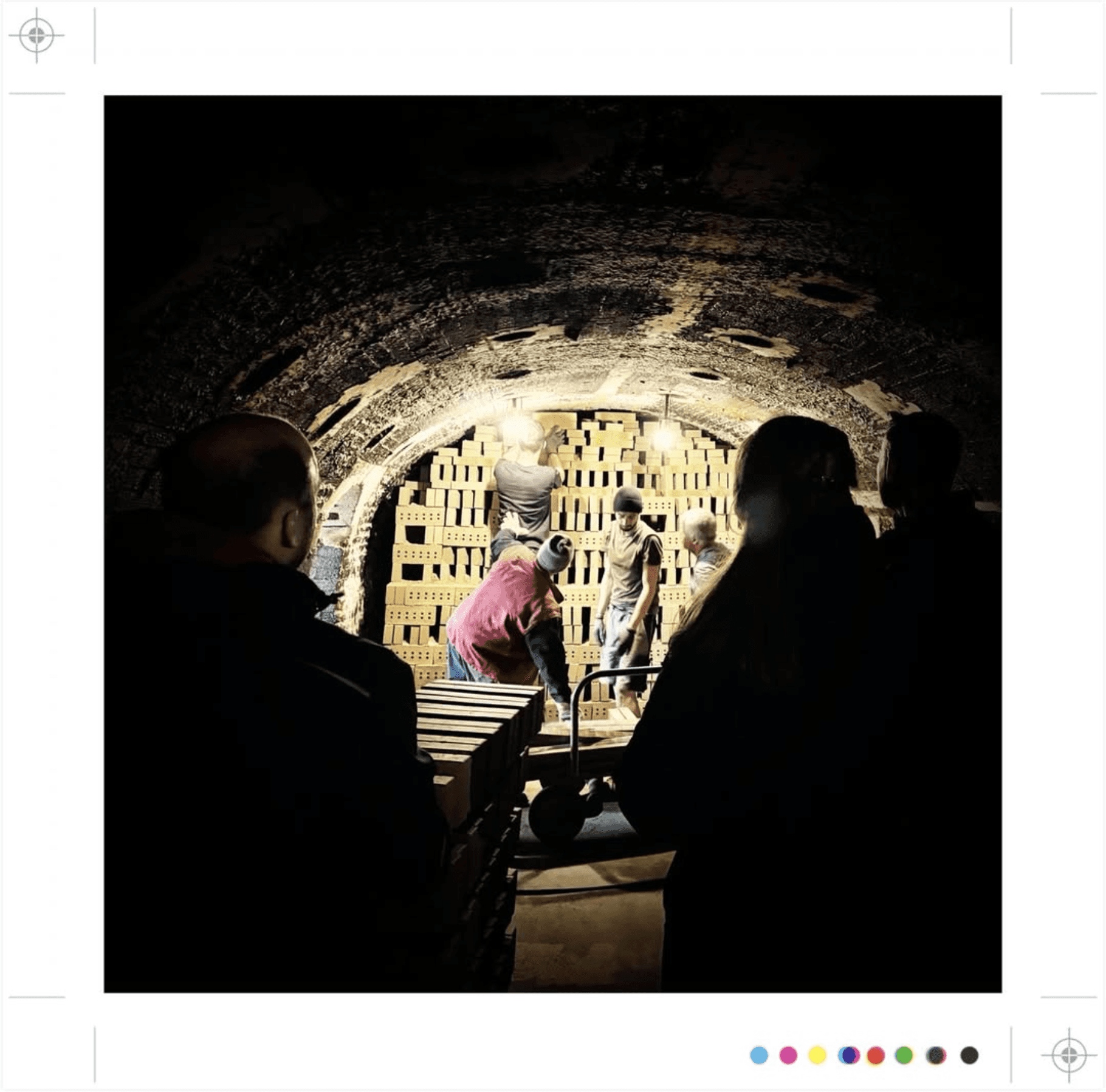 Een groep mensen in een baksteenfabriek, bezig met bakstenen stapelen.