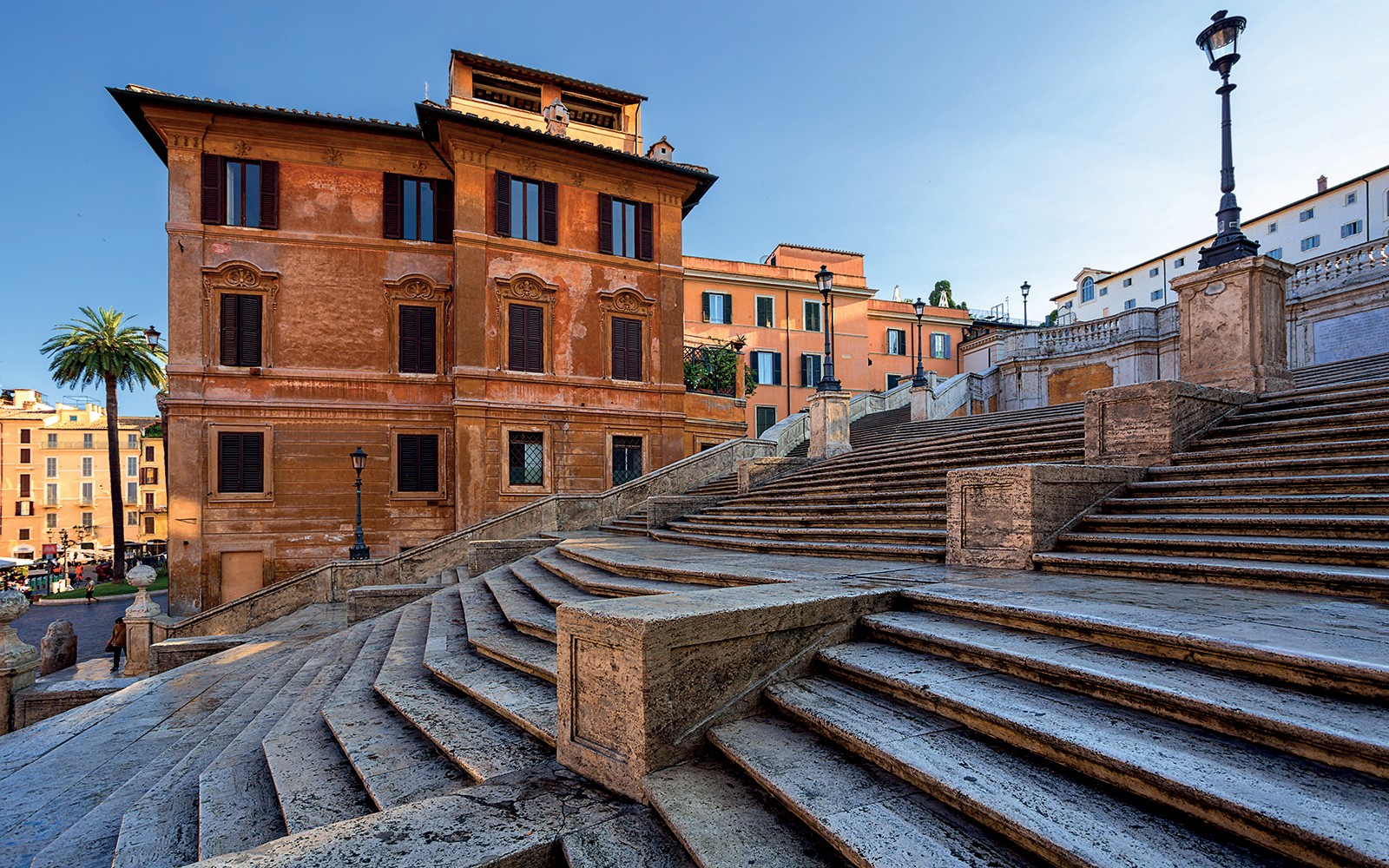 Toeristen zitten op de Spaanse Trappen in Rome, Italië, en genieten van de historische architectuur.