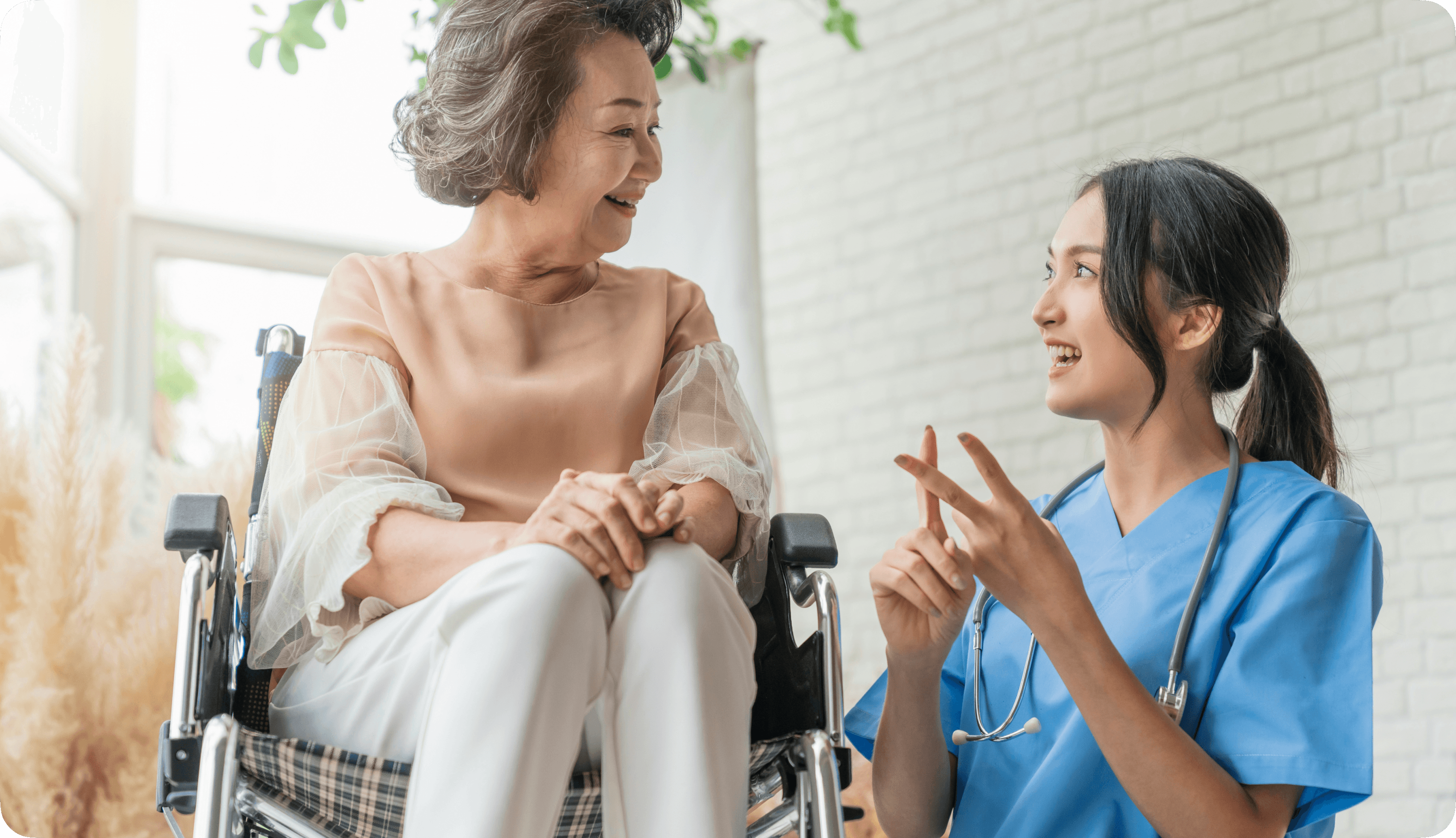 Image of a Nurse with her patient, an senior citizen, smiling.