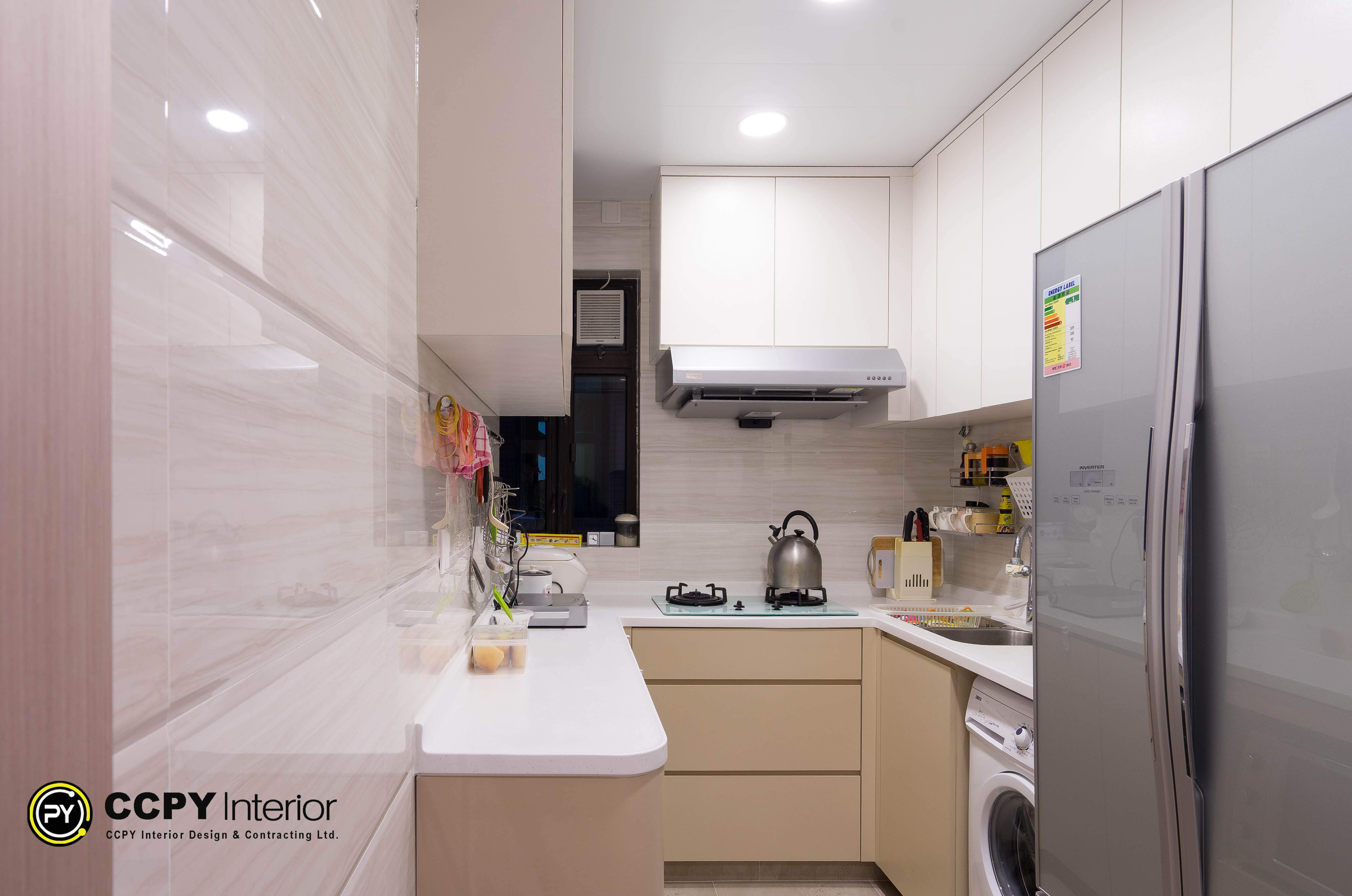 Integrated appliances and clean vertical planes exemplify the minimalist aesthetic in this Castello residential renovation and compact kitchen.