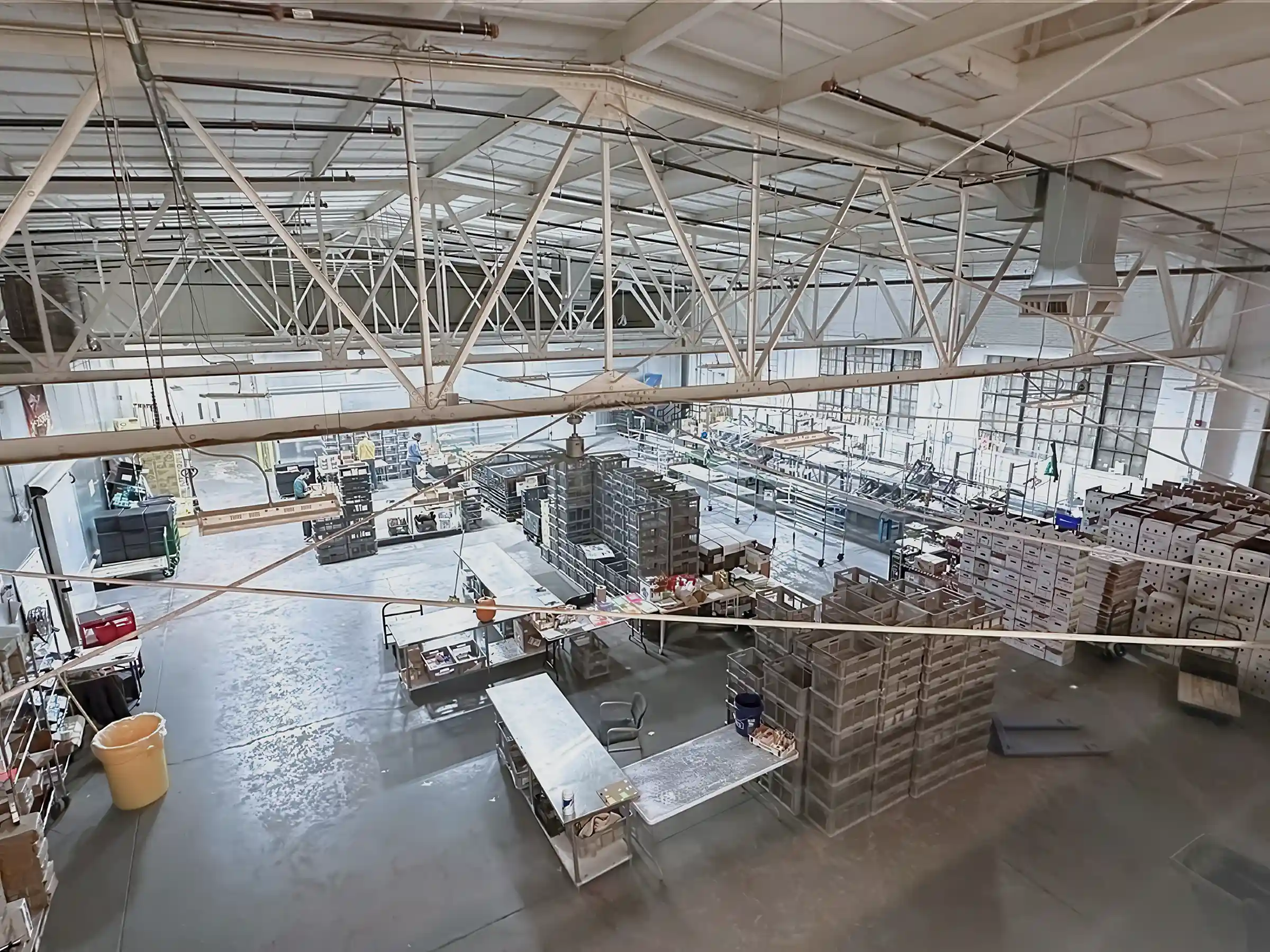 Sealed concrete warehouse flooring in a large Philly Food Works food distribution facility with steel trusses and industrial shelving.