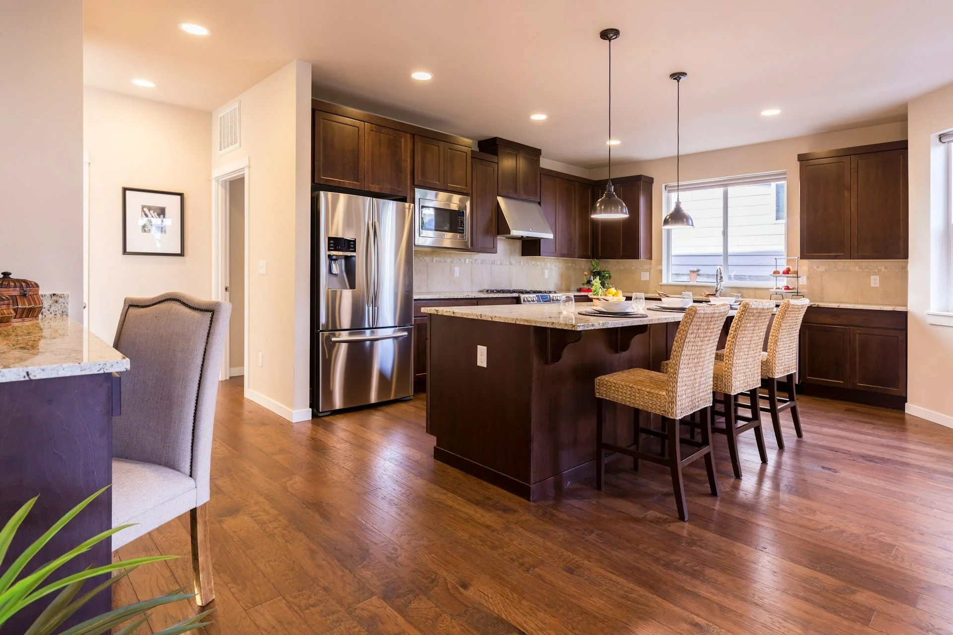 Modern kitchen with island seating and wooden cabinets.