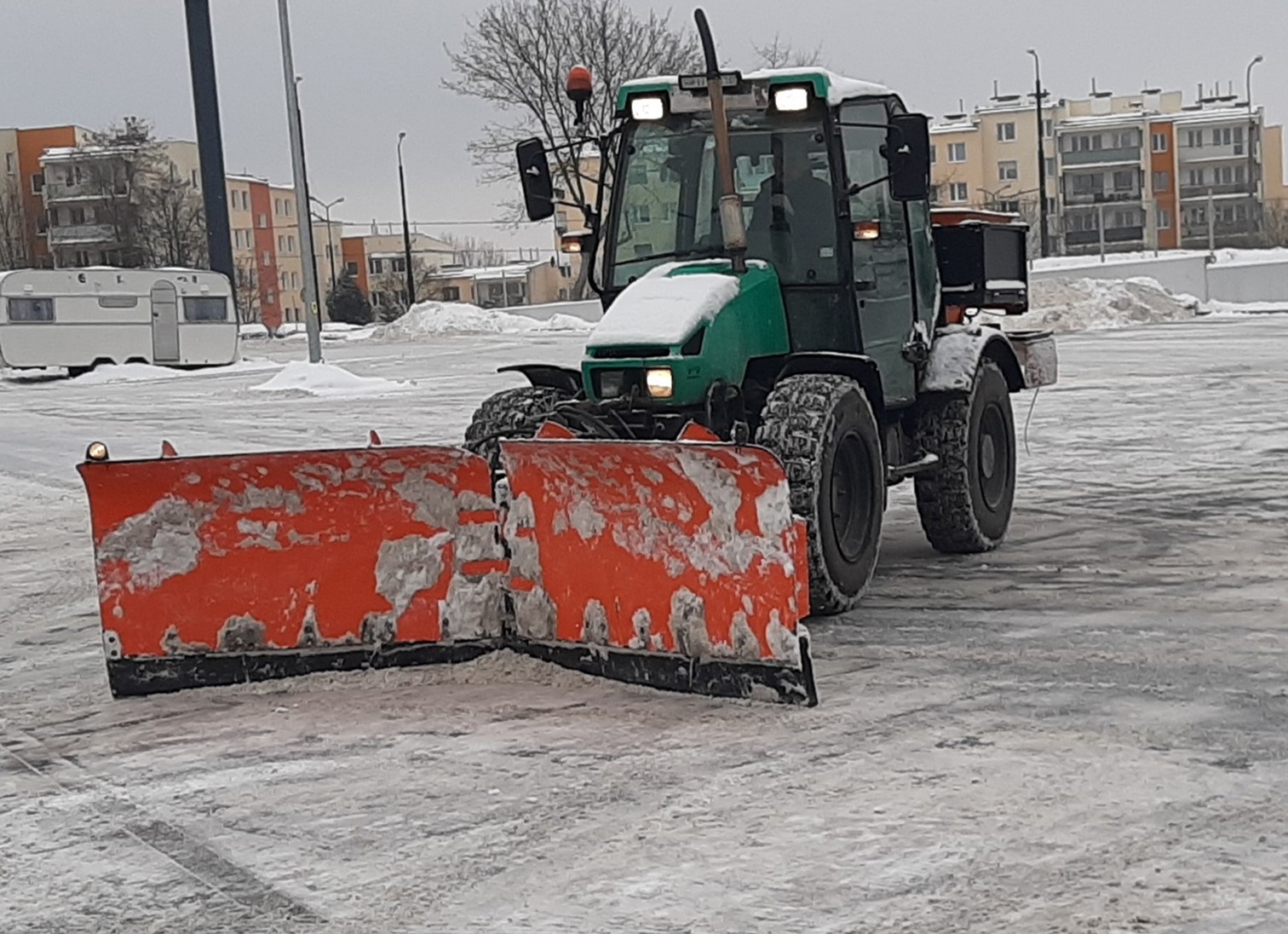 Odśnieżanie parkingu traktorem i solenie
