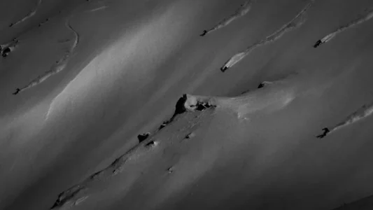 A ski slobe with 6 skiers going down the mountain