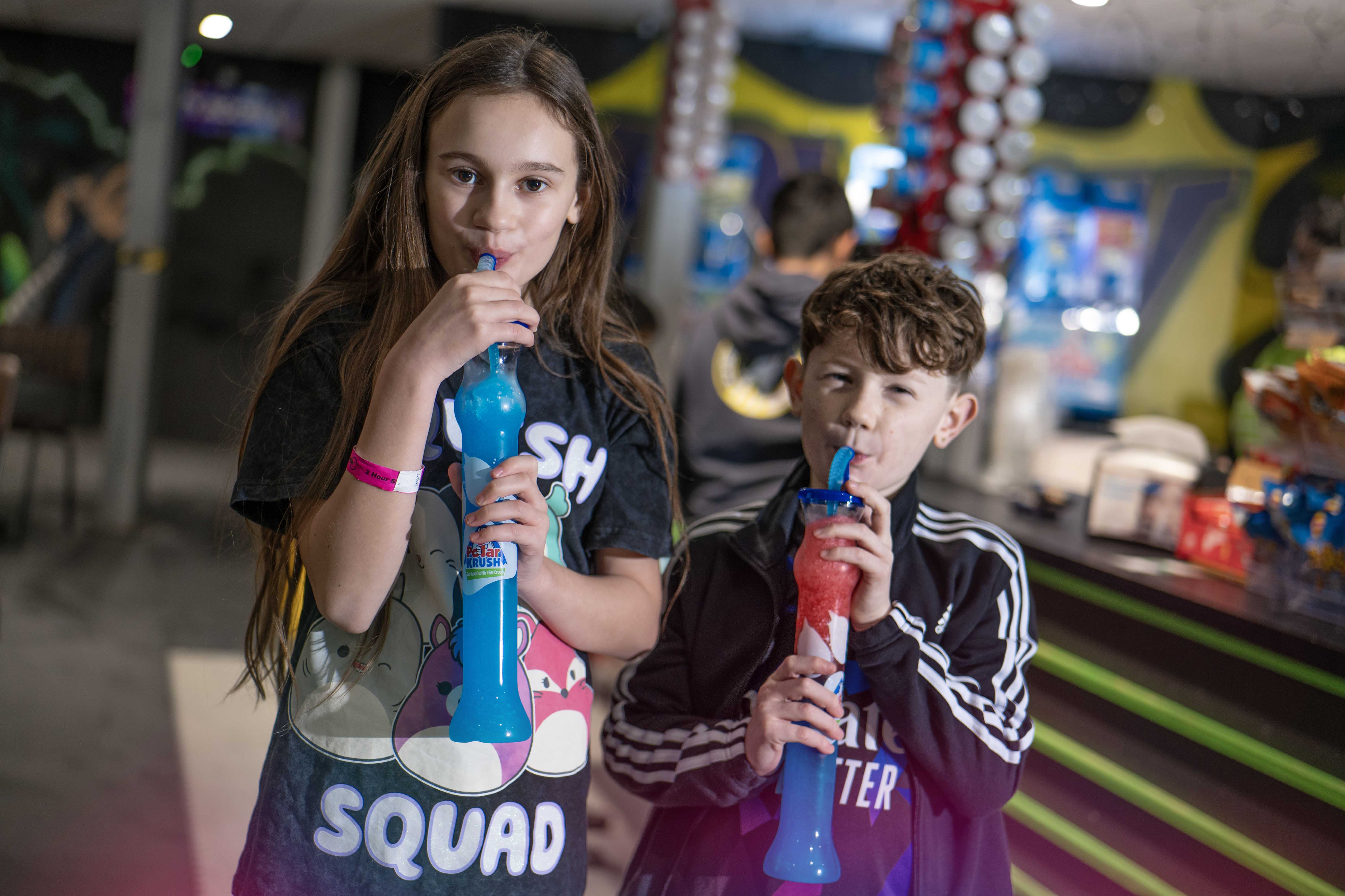 Young girl and biy drinking on slush at Flip Out Adventure Park