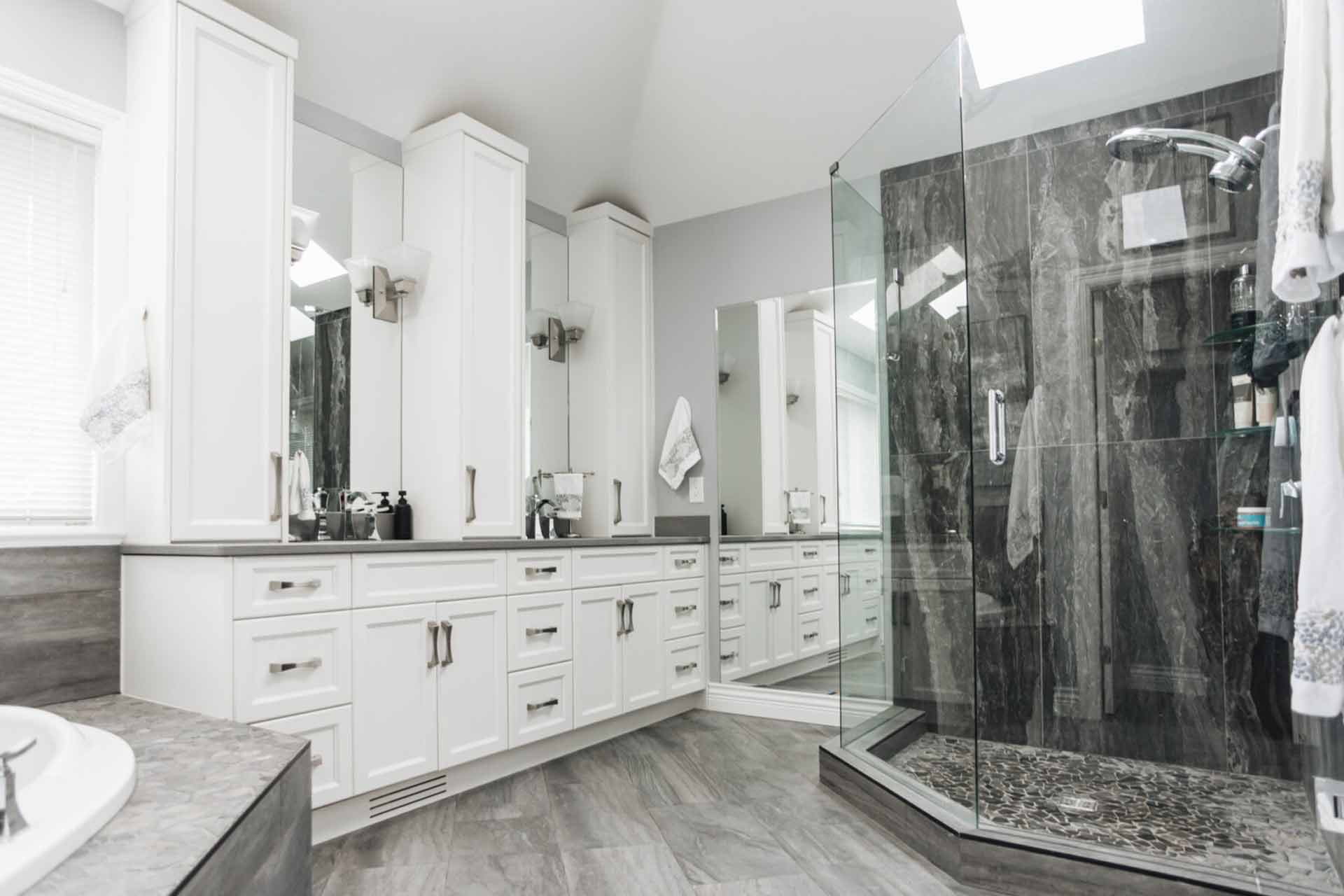 interior designed bathroom white cabinets dark grey shower tile