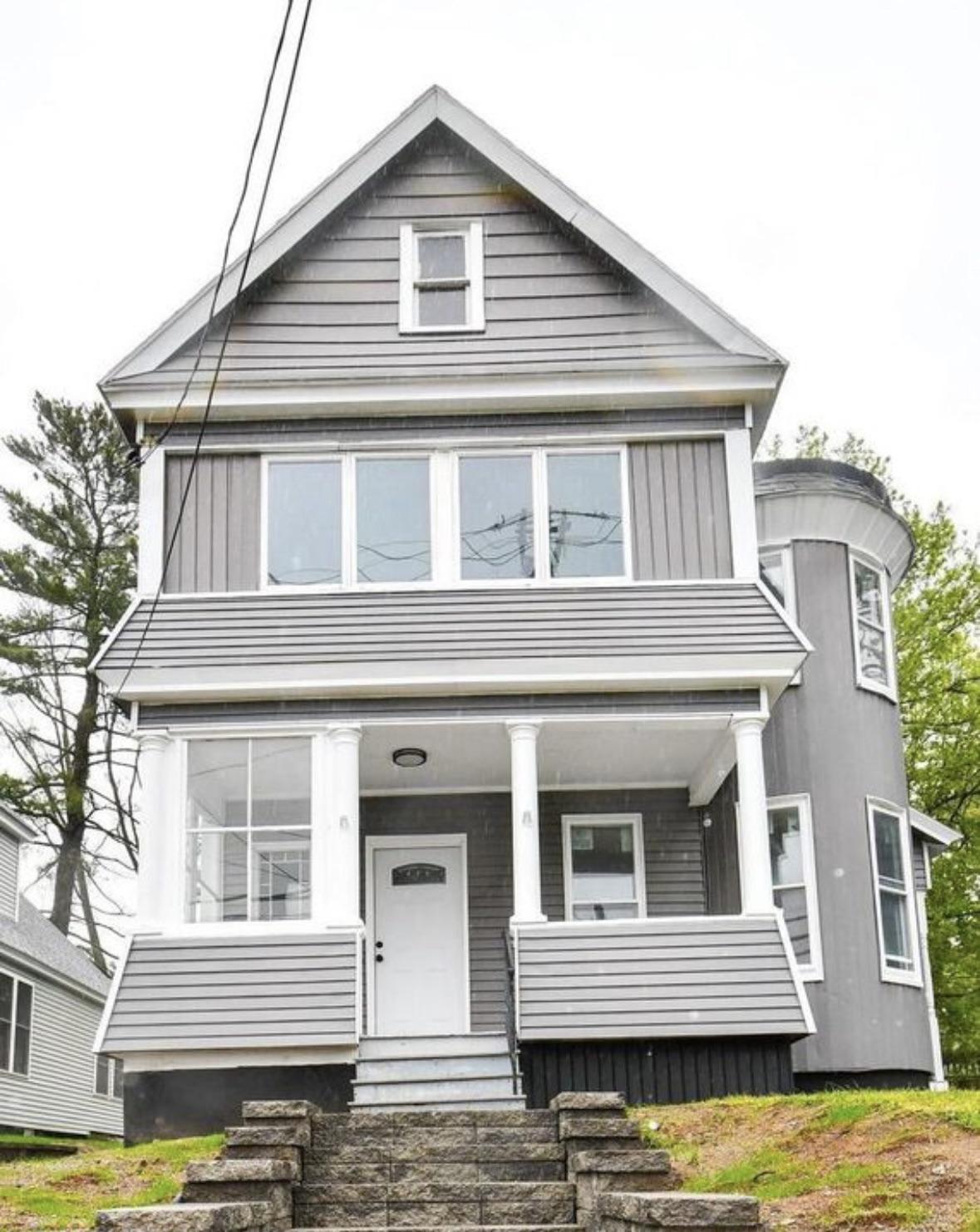 The original Victorian — all gray siding, no landscaping, cold and institutional despite strong architectural details
