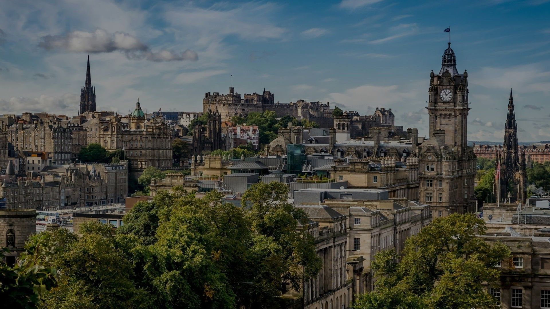A large christmas tree in front of a tall building